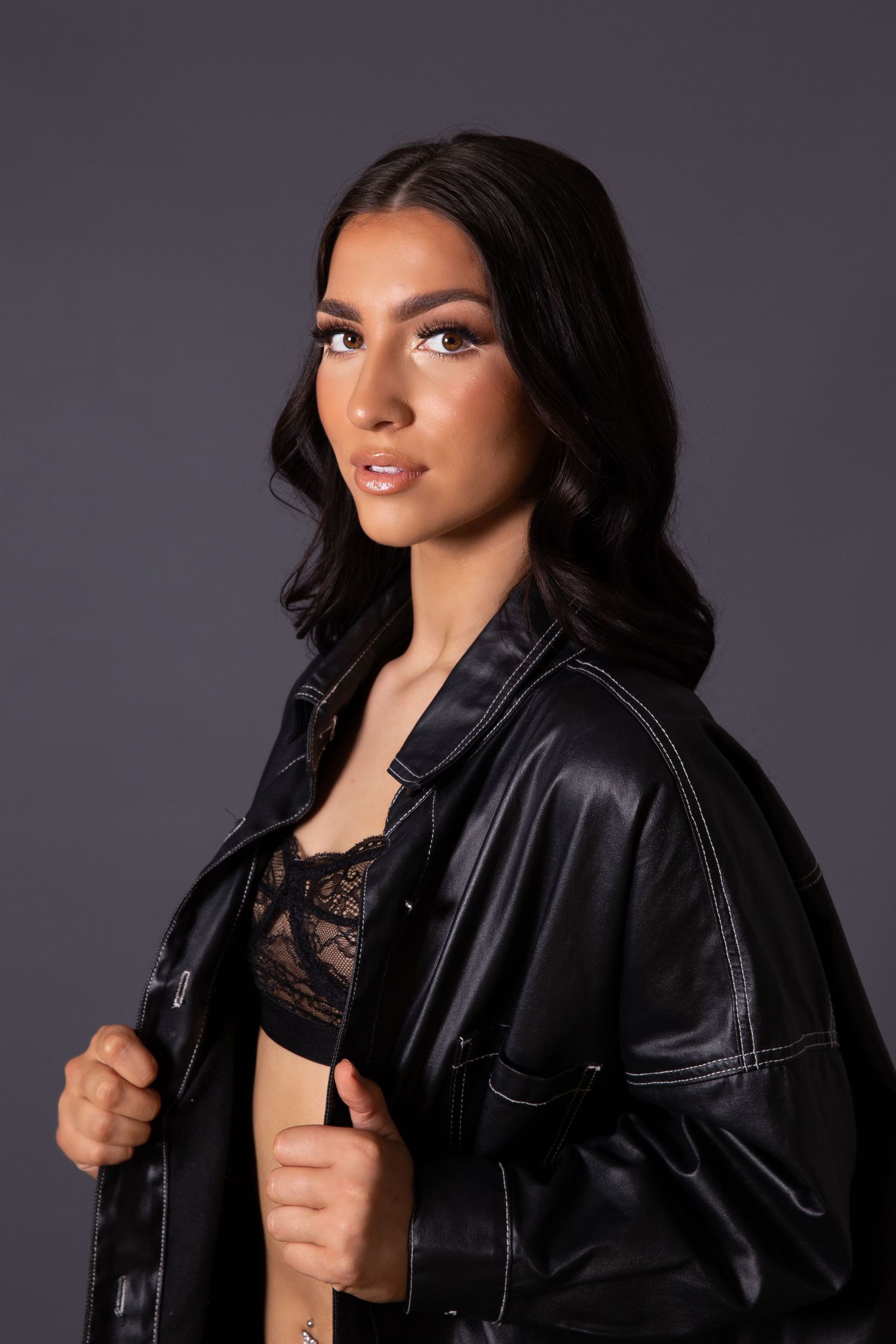 A series of four professional portraits featuring a model wearing a black leather jacket against a dark background.