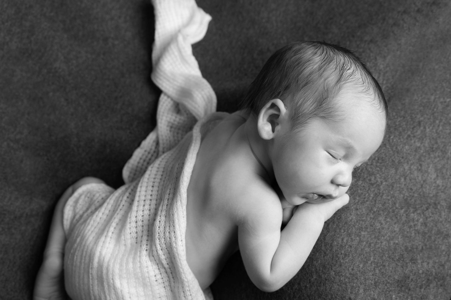 A sweet black and white photo collage shows a sleeping newborn baby in different peaceful poses.