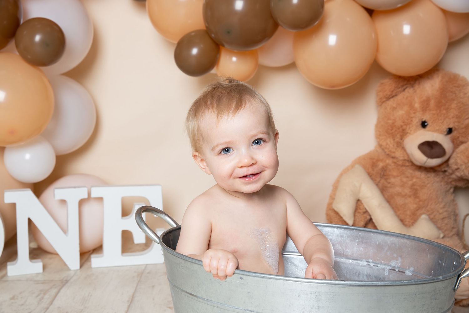 Banner collage of baby portraits with balloons and decorative elements in soft beige and brown tones.