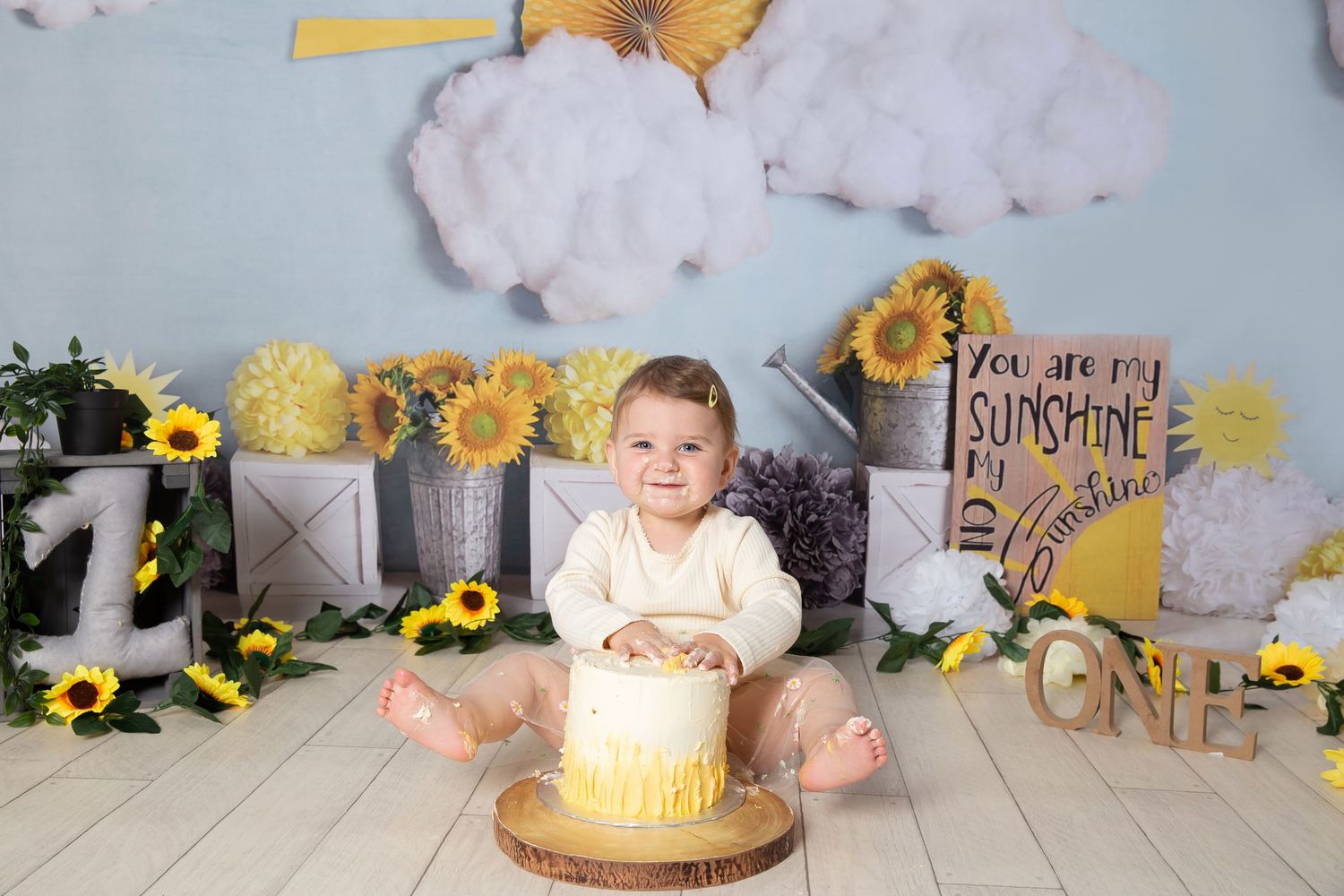 Collage of cake smash photo session with yellow sunflower theme and rustic decor against gray backdrop.