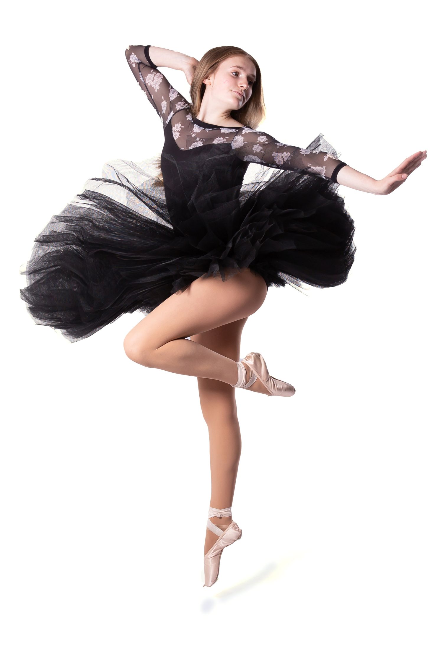 Graceful dancer in black tutu and lace performs elegant leaps in a dynamic photo sequence.