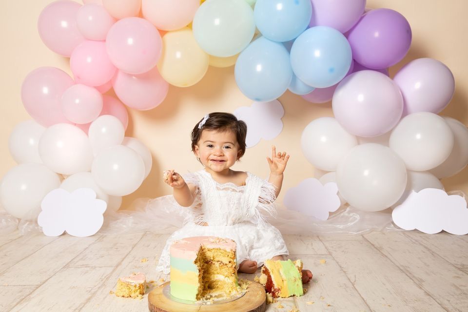 Pastel balloon garland decorates a cream-colored wall for a festive celebration setting.