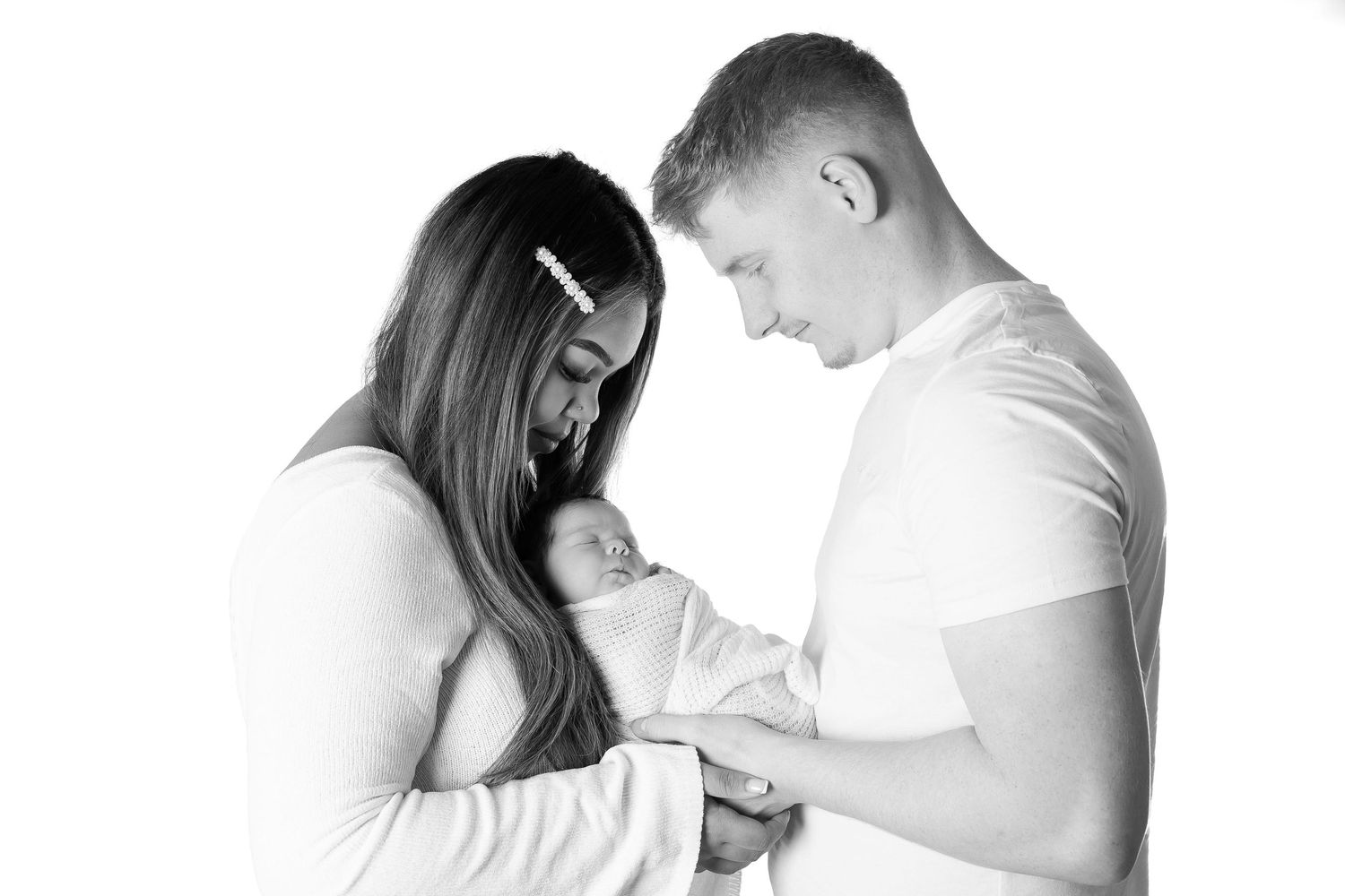 Three black and white images show intimate moments of breastfeeding between mother and baby.