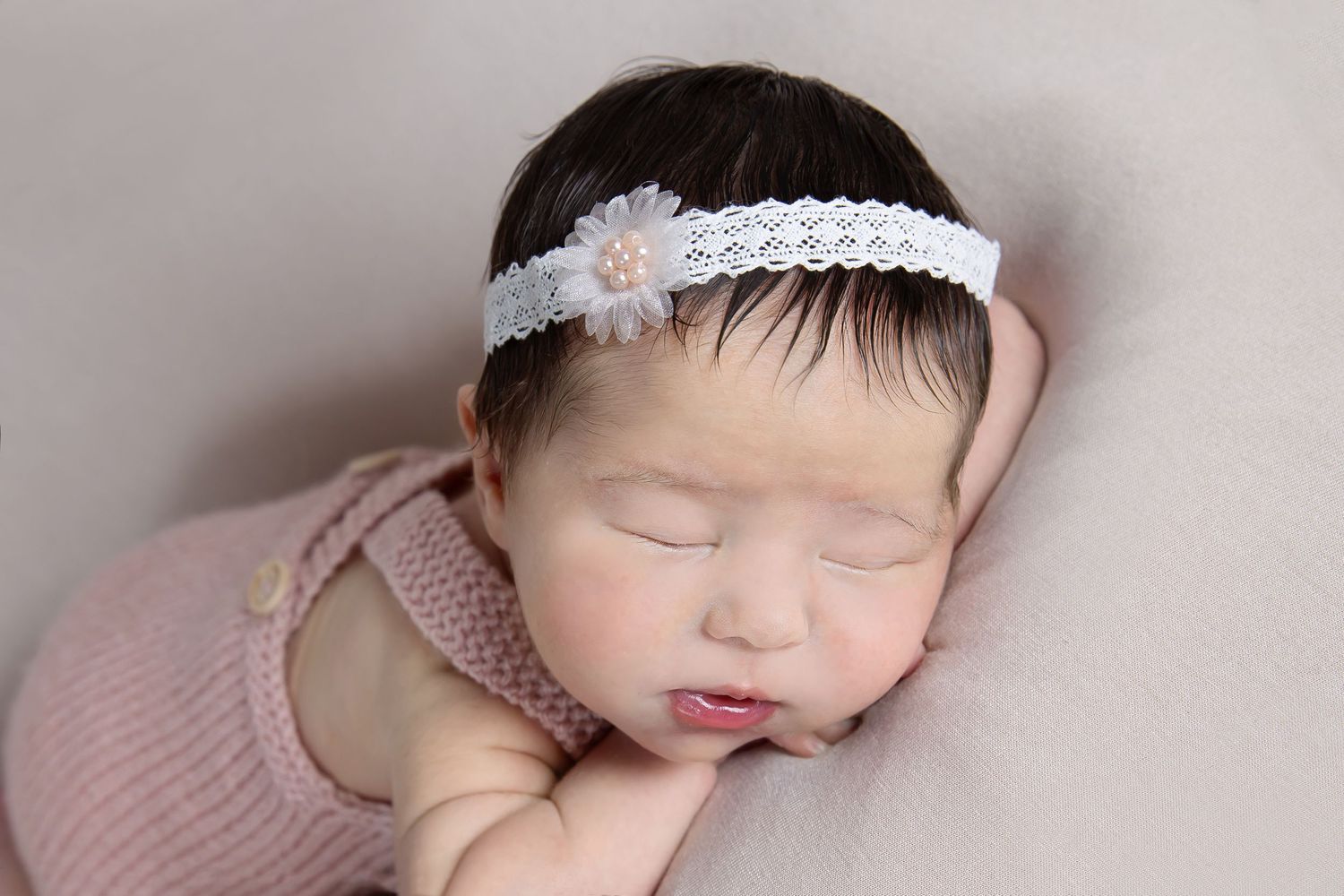 A collage of six artistic newborn baby portraits with soft pink tones and delicate headband accessories.