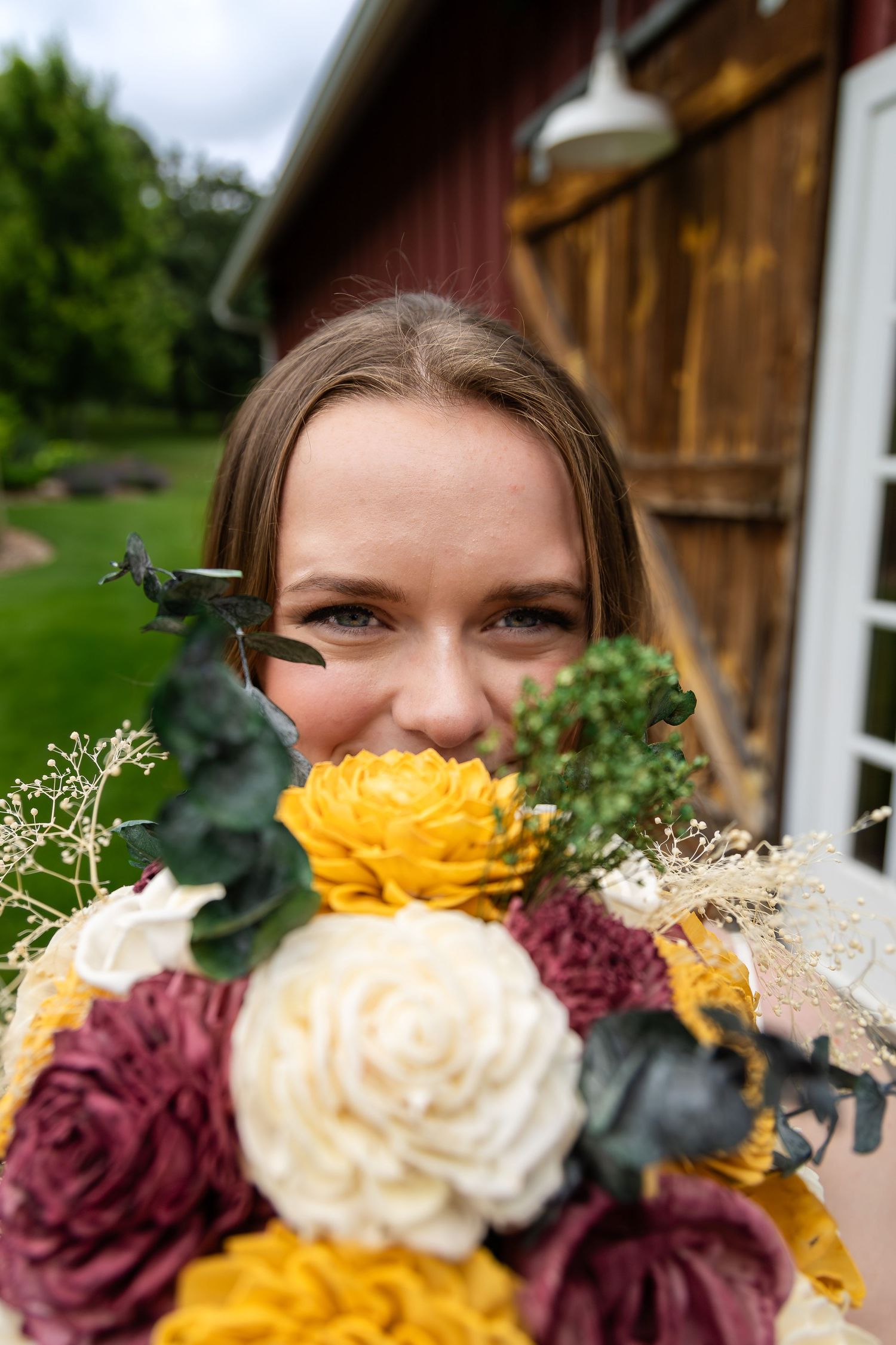 Wedding bouquet featuring burgundy and yellow roses with delicate baby's breath accents.
