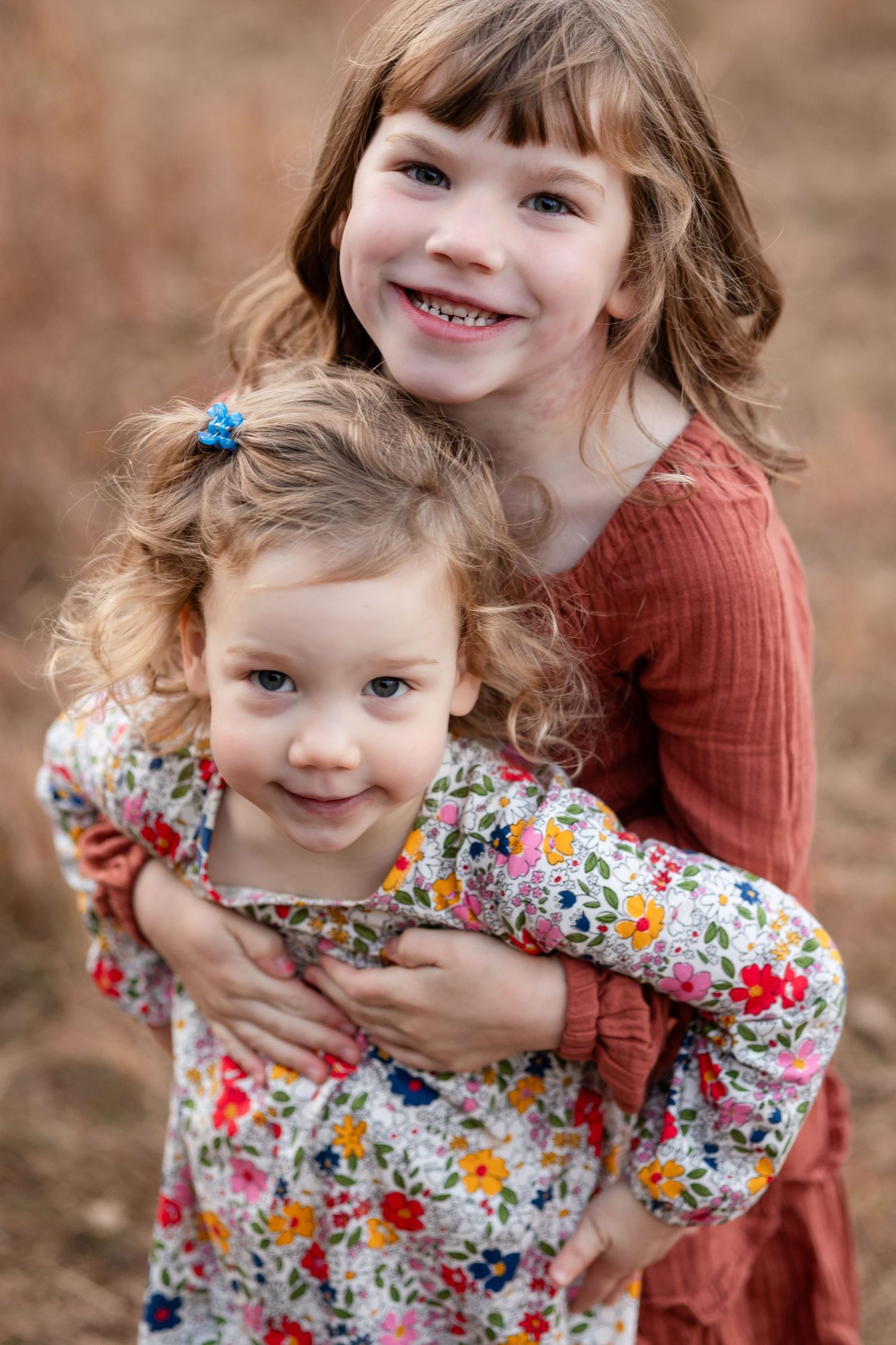 Close up portrait of siblings sharing joyful moment outdoors.