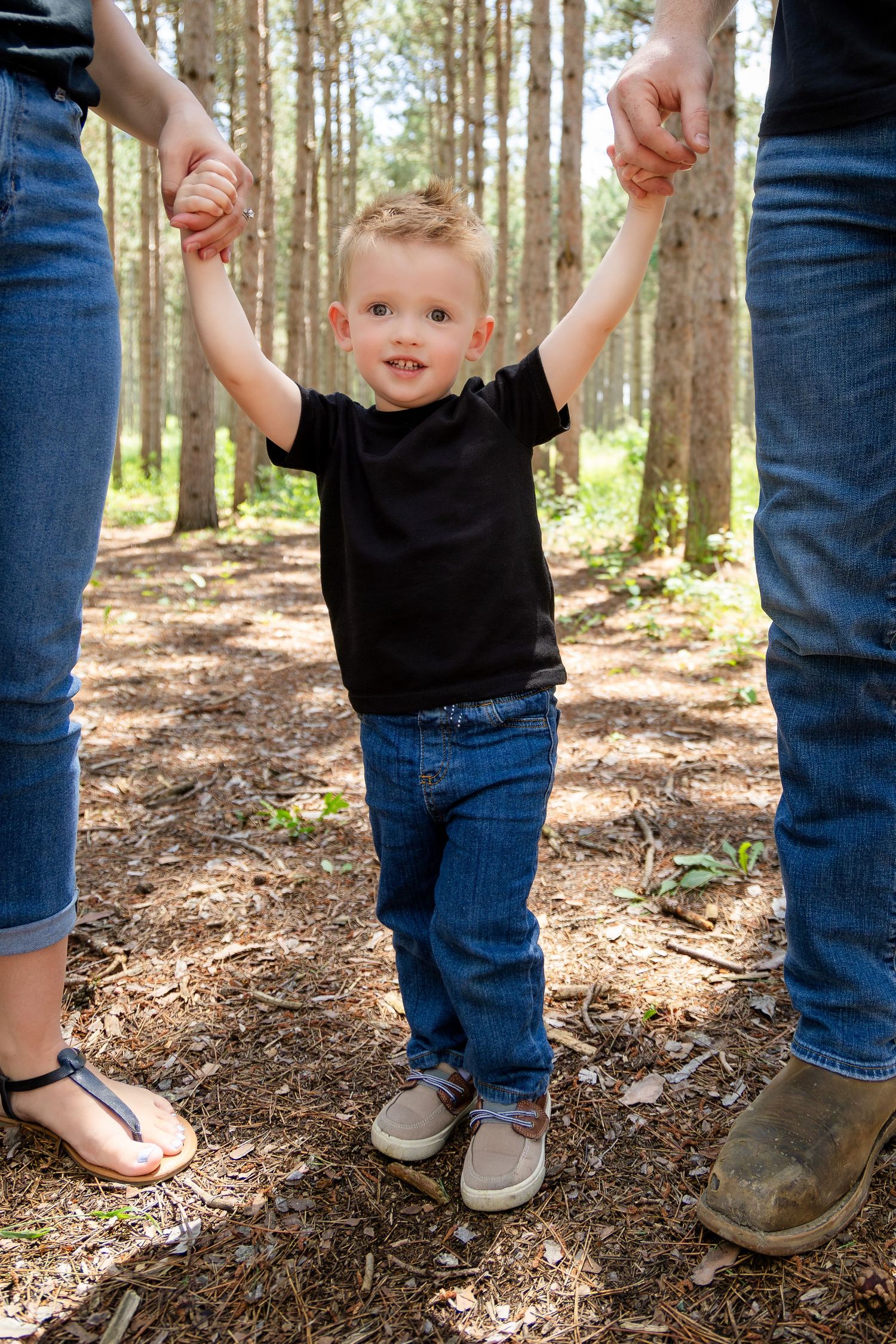 Close-up shots of feet and legs walking together on a forest trail.