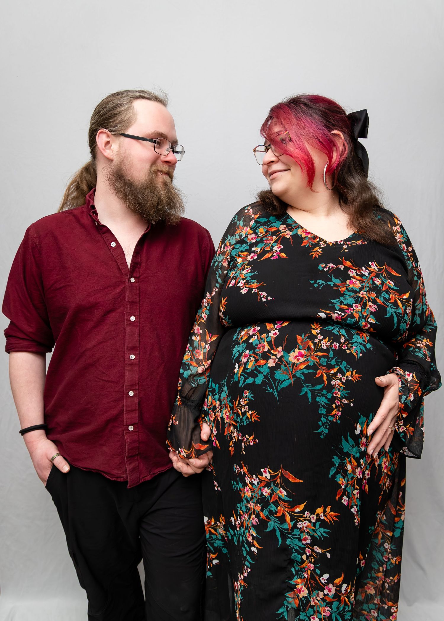 A couple in burgundy and floral outfits poses playfully in a photo studio sequence showing different romantic poses.
