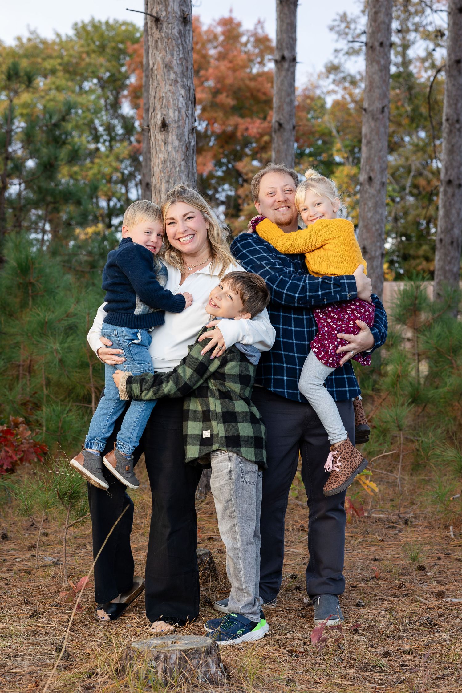 Family members playing and posing playfully in a wooded setting.
