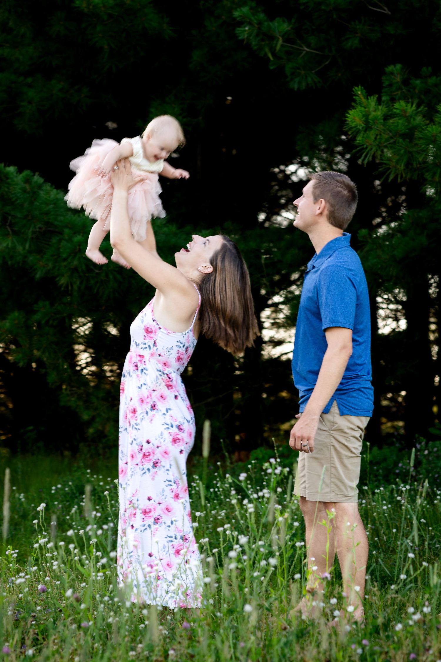 A family shares a joyful moment together in a wildflower meadow on a summer evening.
