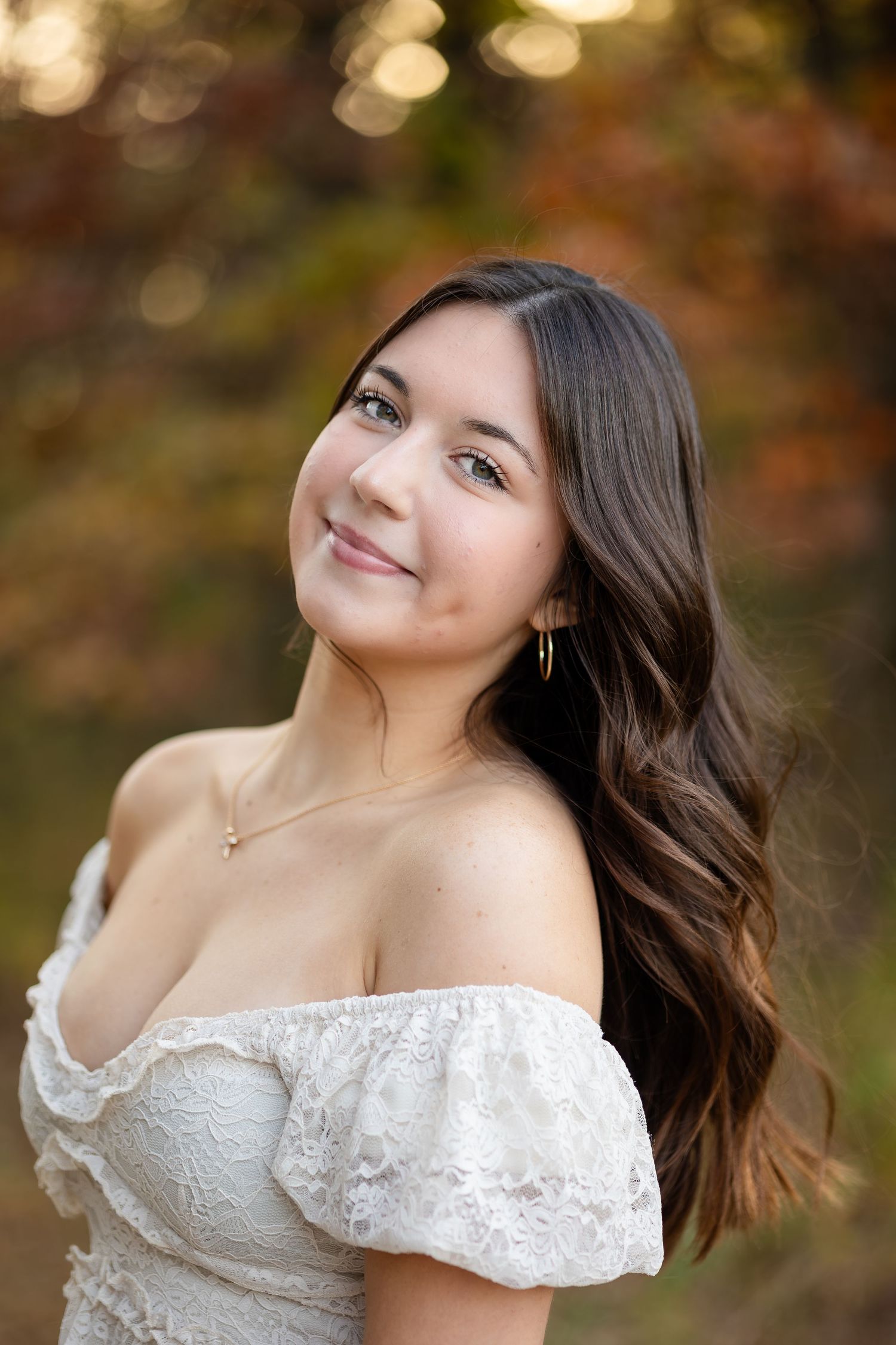 Soft focus portrait with white lace top against bokeh background.