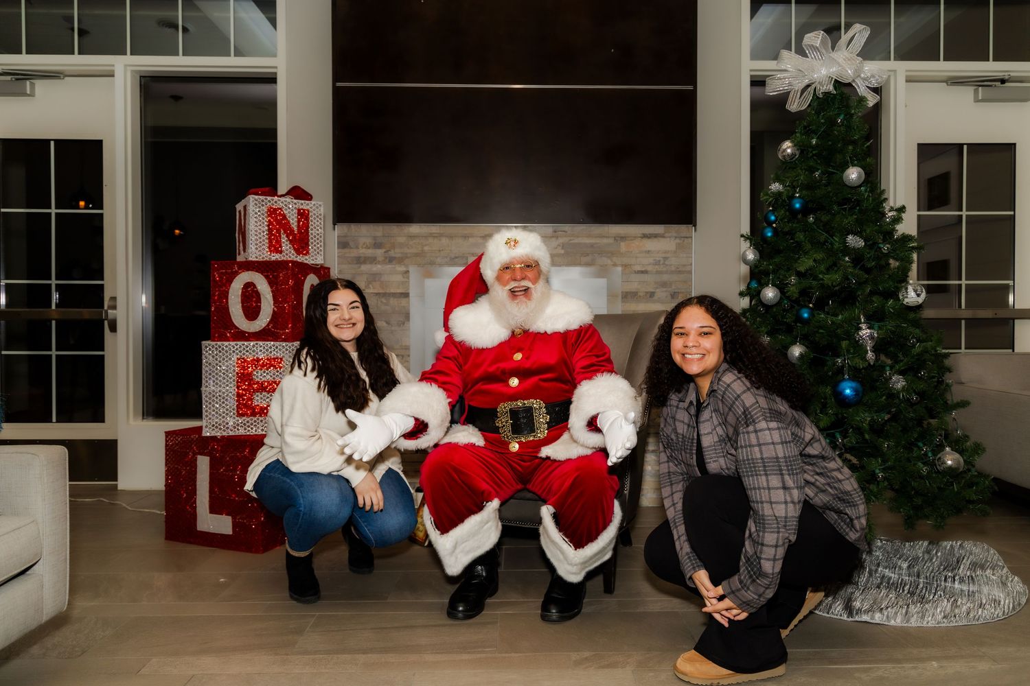 Festive holiday photo setup with Christmas tree, decorative letters, and seasonal props.