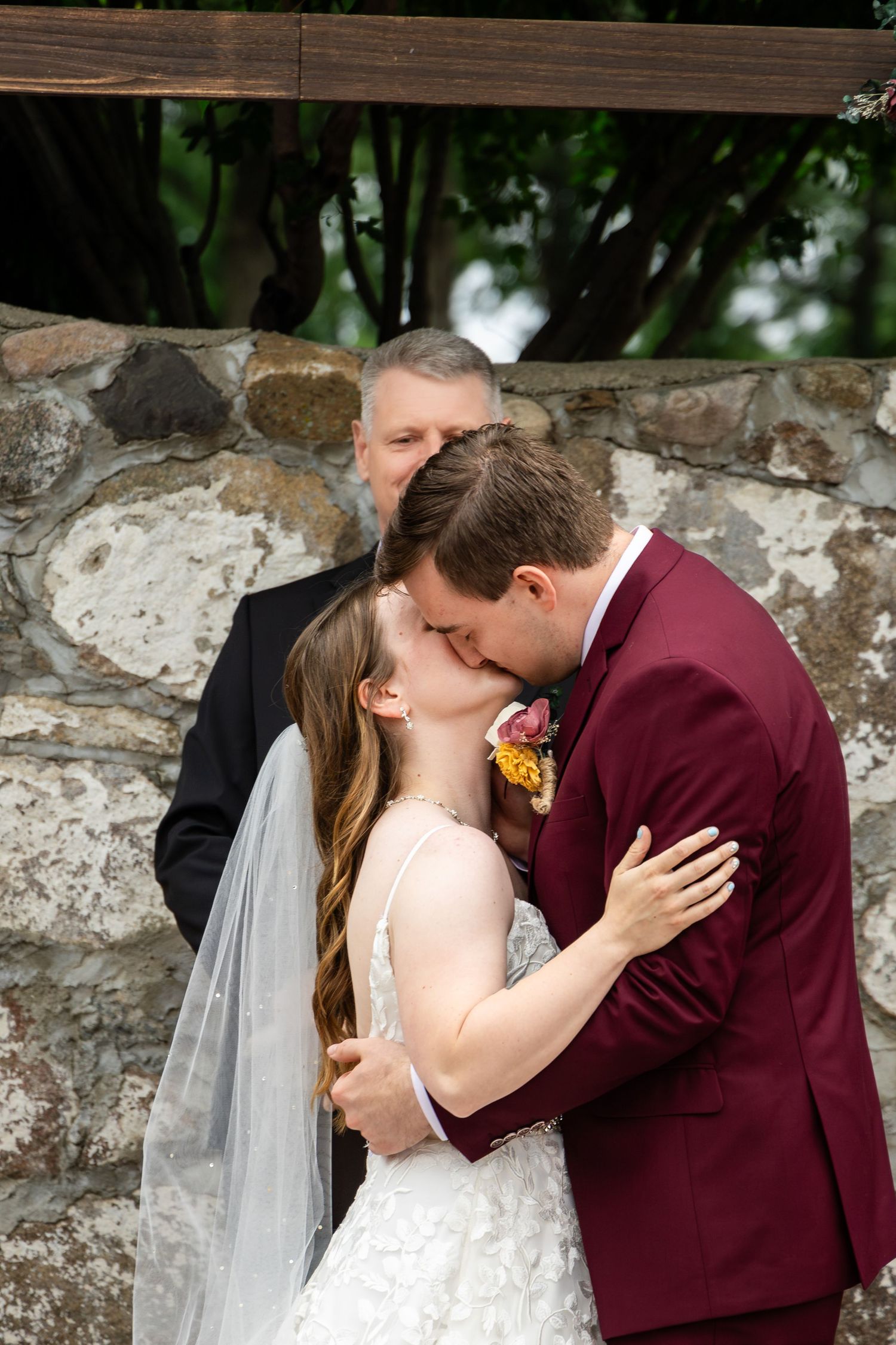 A wedding sequence showing a romantic kiss against a rustic stone wall backdrop.