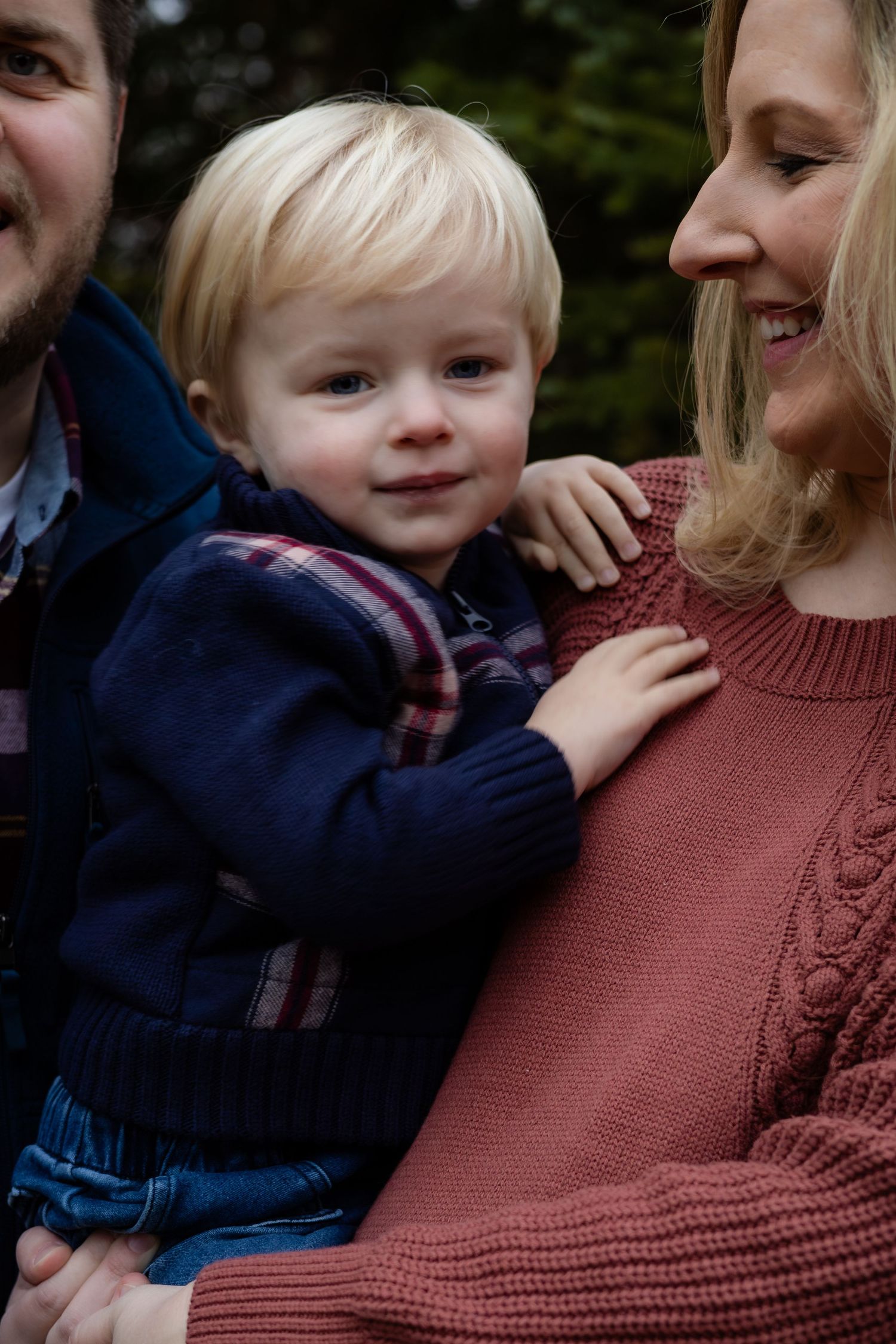 A tender family moment shared while wearing cozy fall clothing outdoors.