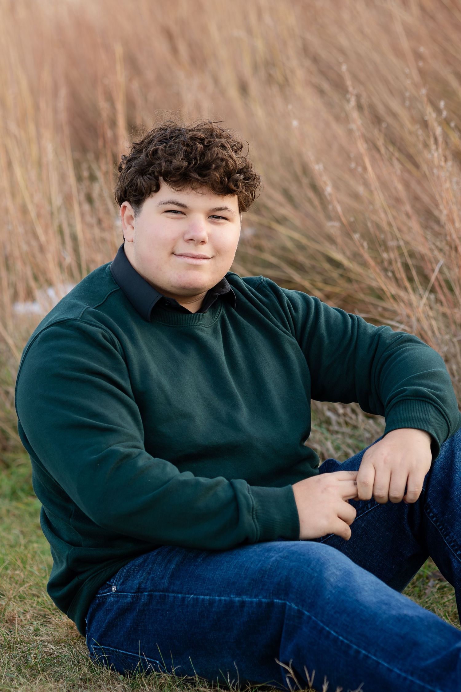 Portrait in dark sweater against golden grass during autumn.