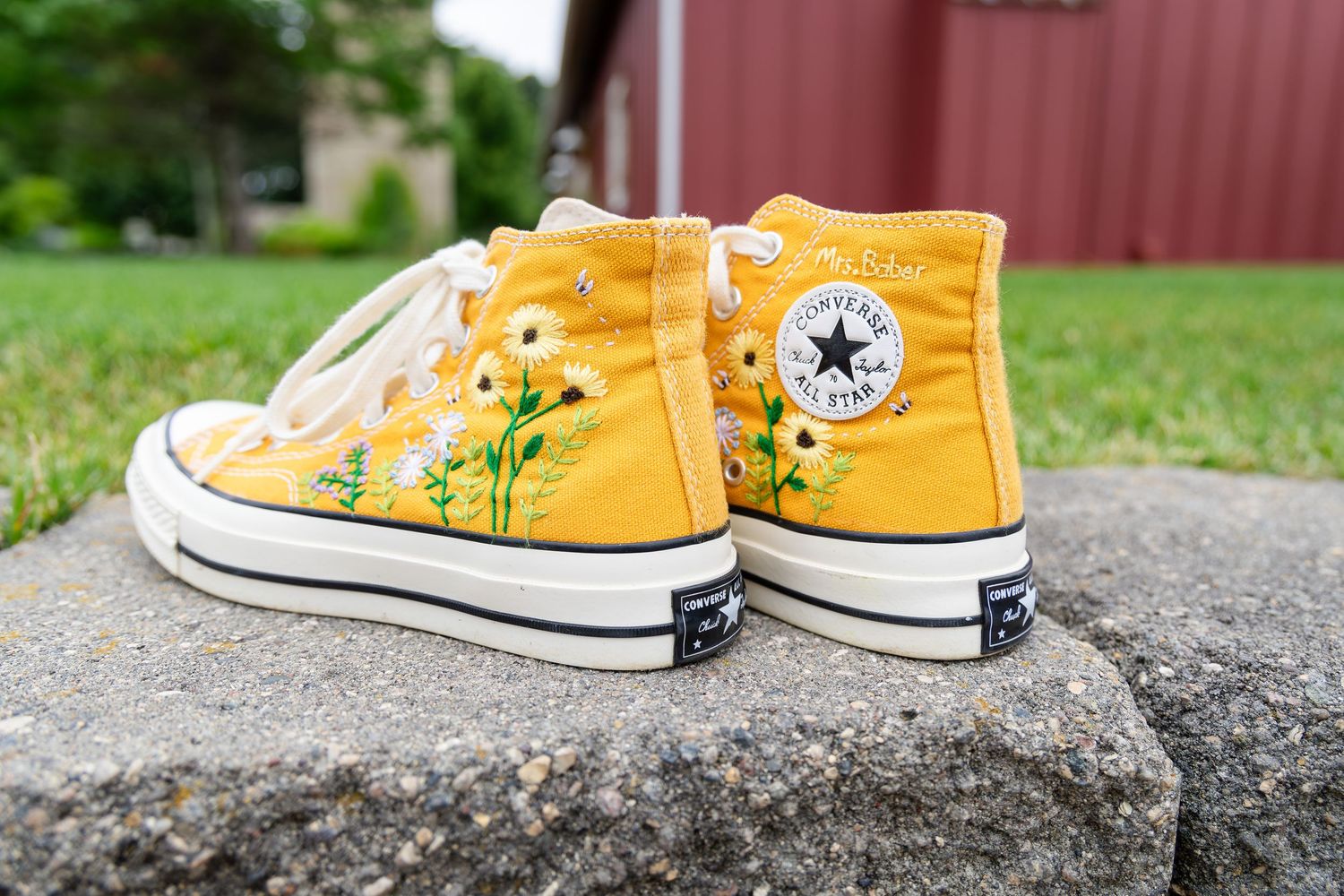 Yellow Converse sneakers arranged on stone surface for wedding detail shot.