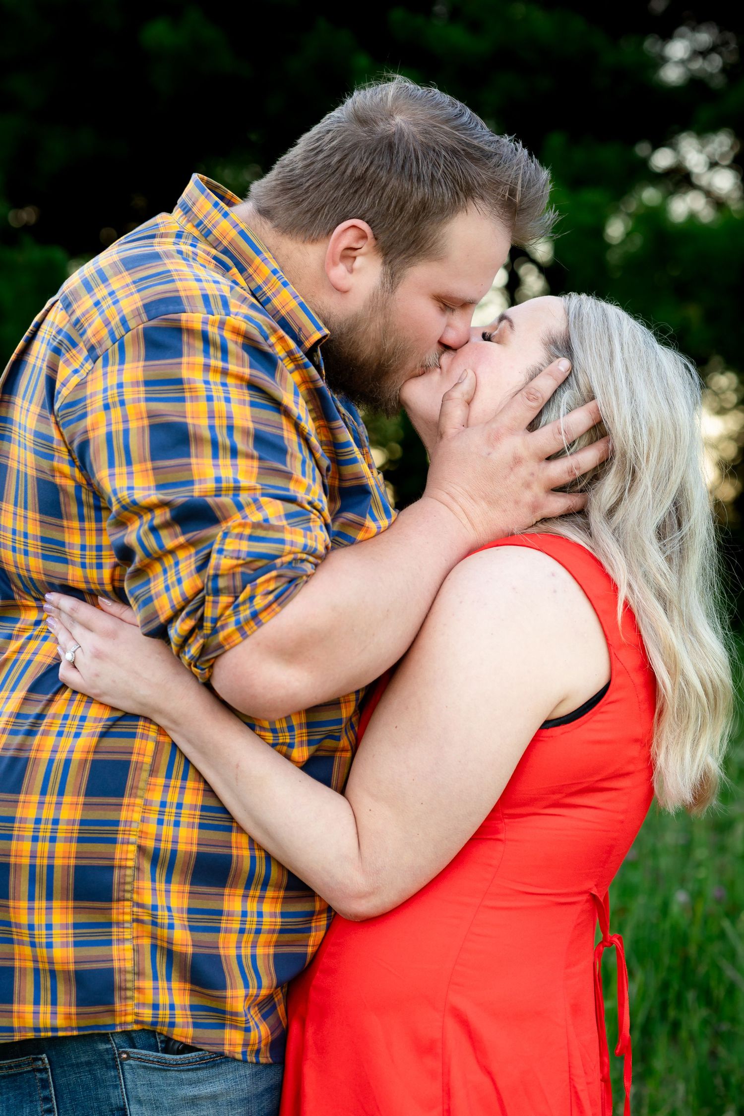 A tender embrace between a couple during an outdoor photo shoot.