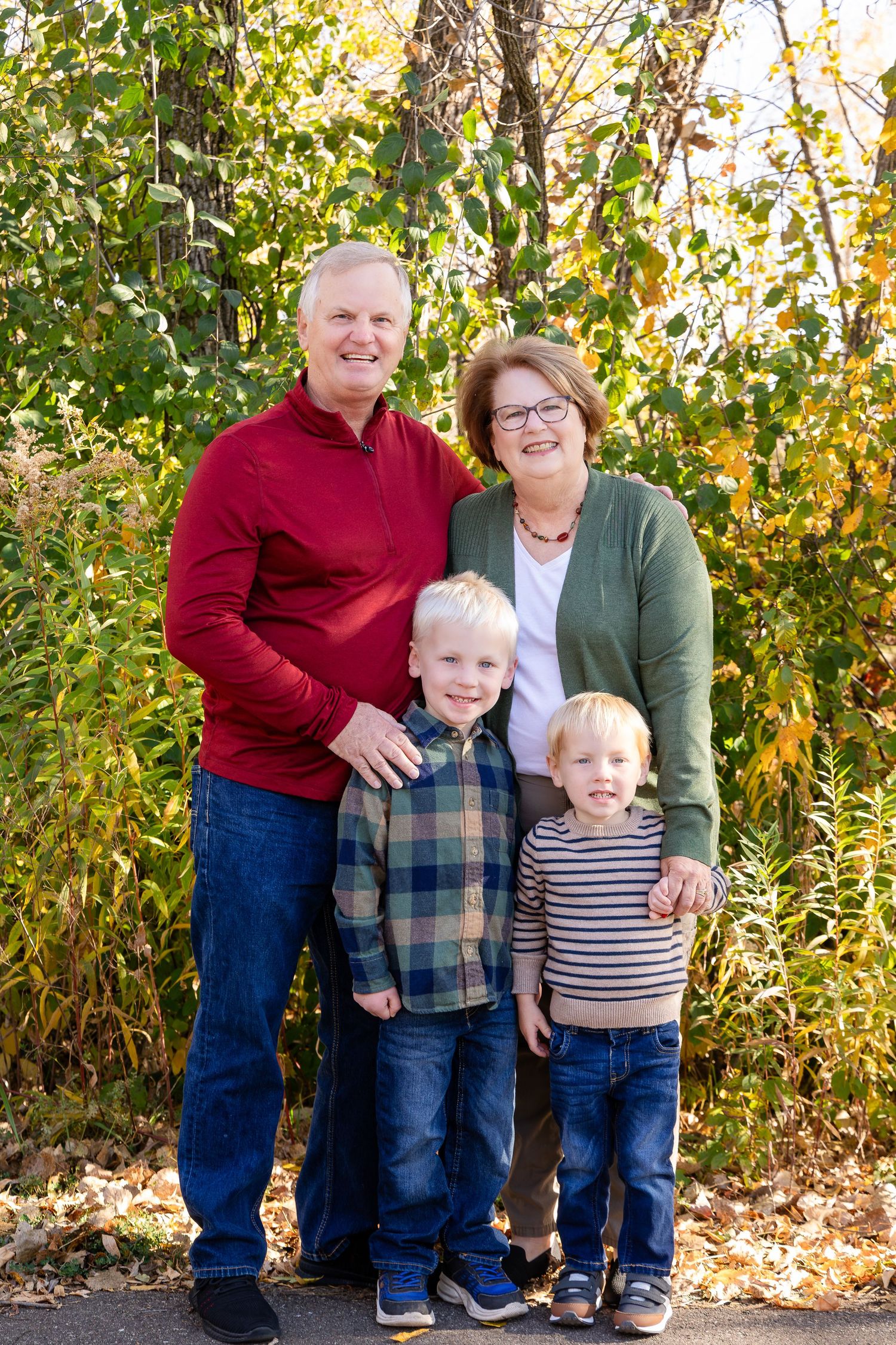 Autumn family portrait with fall foliage in natural outdoor setting.