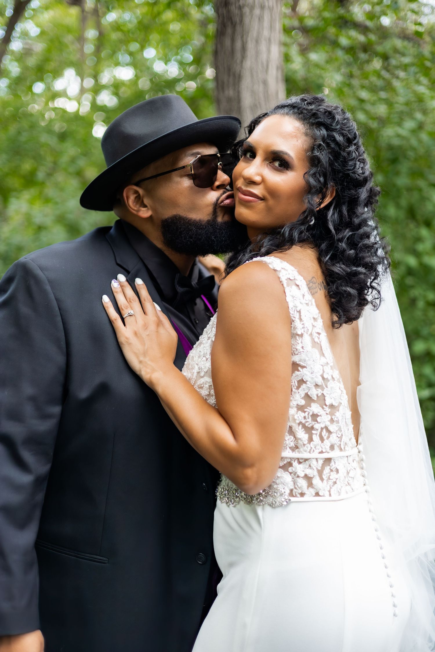A romantic moment between newlyweds, with the bride wearing a lace dress and veil.