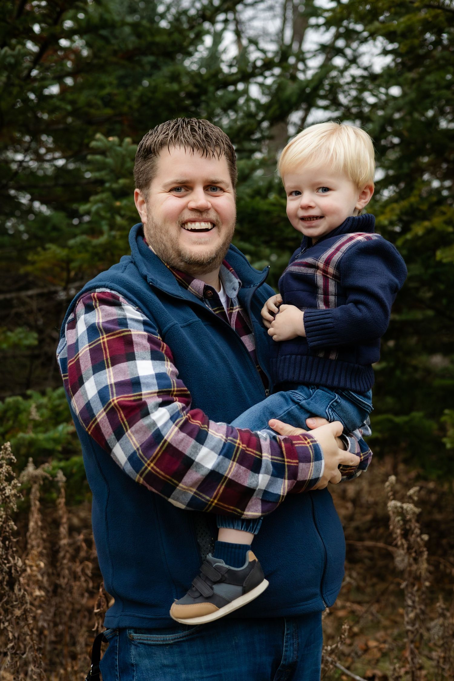 A playful moment captured between adults and a small child in casual outdoor wear.