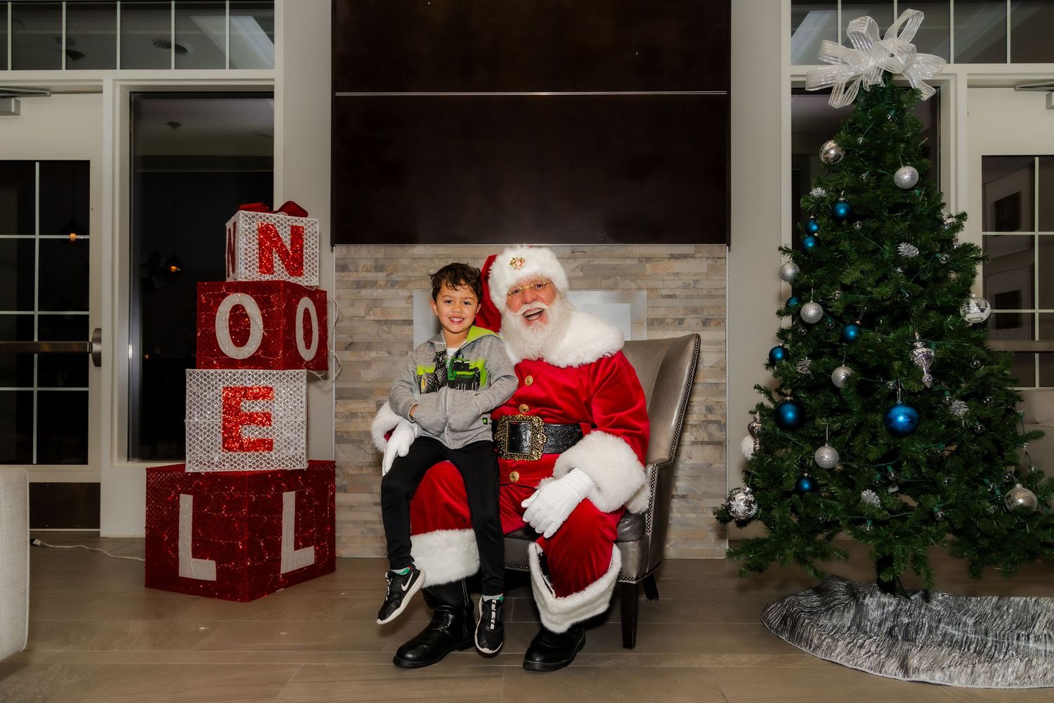 Christmas photo area with decorated tree, red NOEL letters, and festive backdrop.