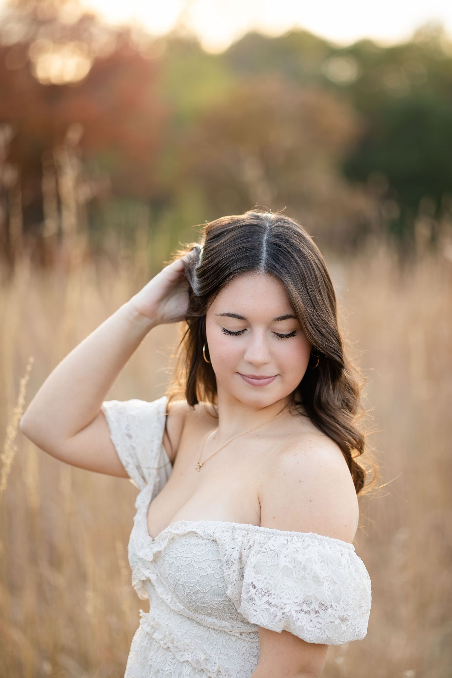 Golden hour portrait session in field with white off-shoulder lace top.
