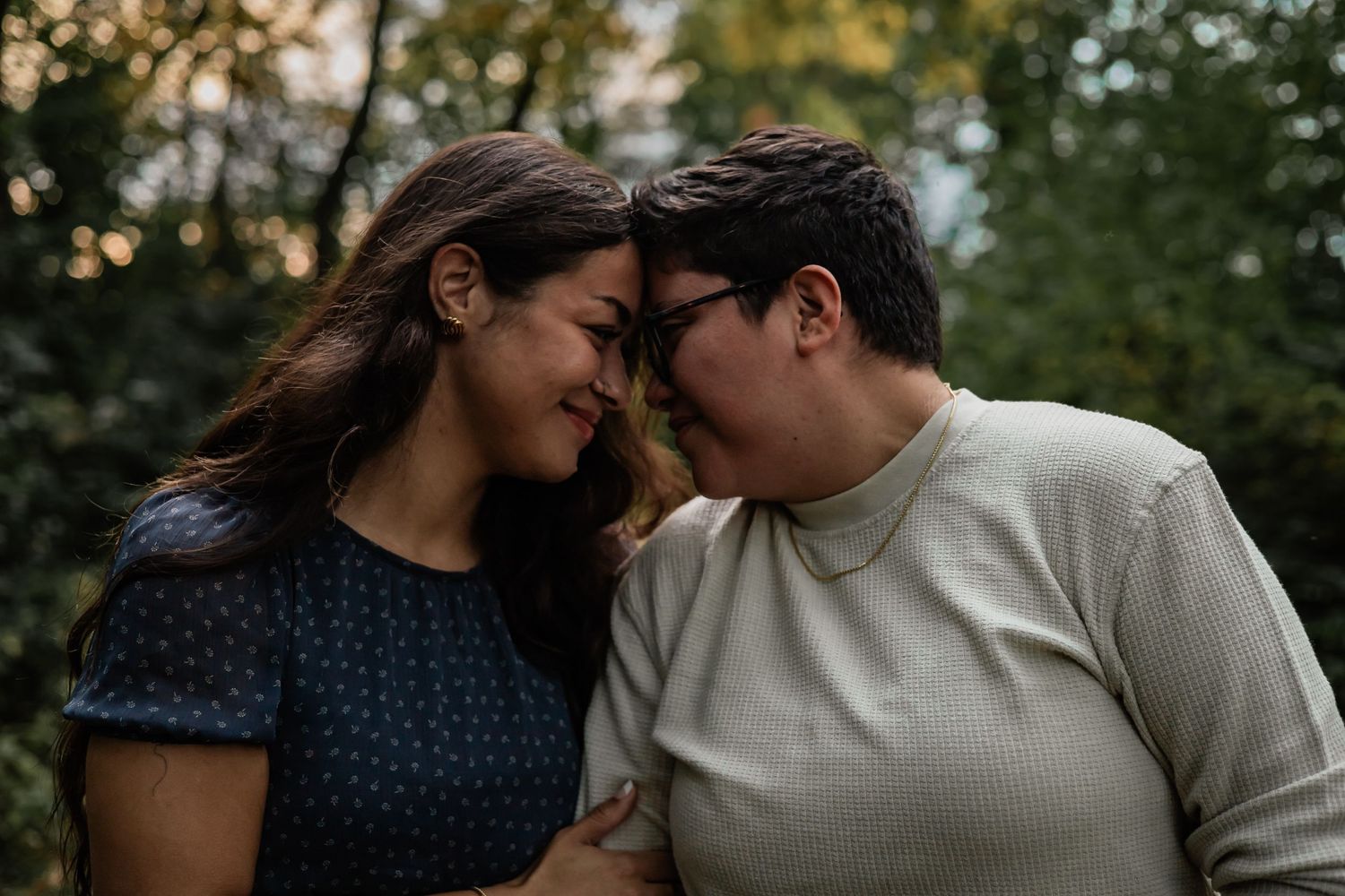 Intimate couple moments captured in a wooded setting during golden hour.