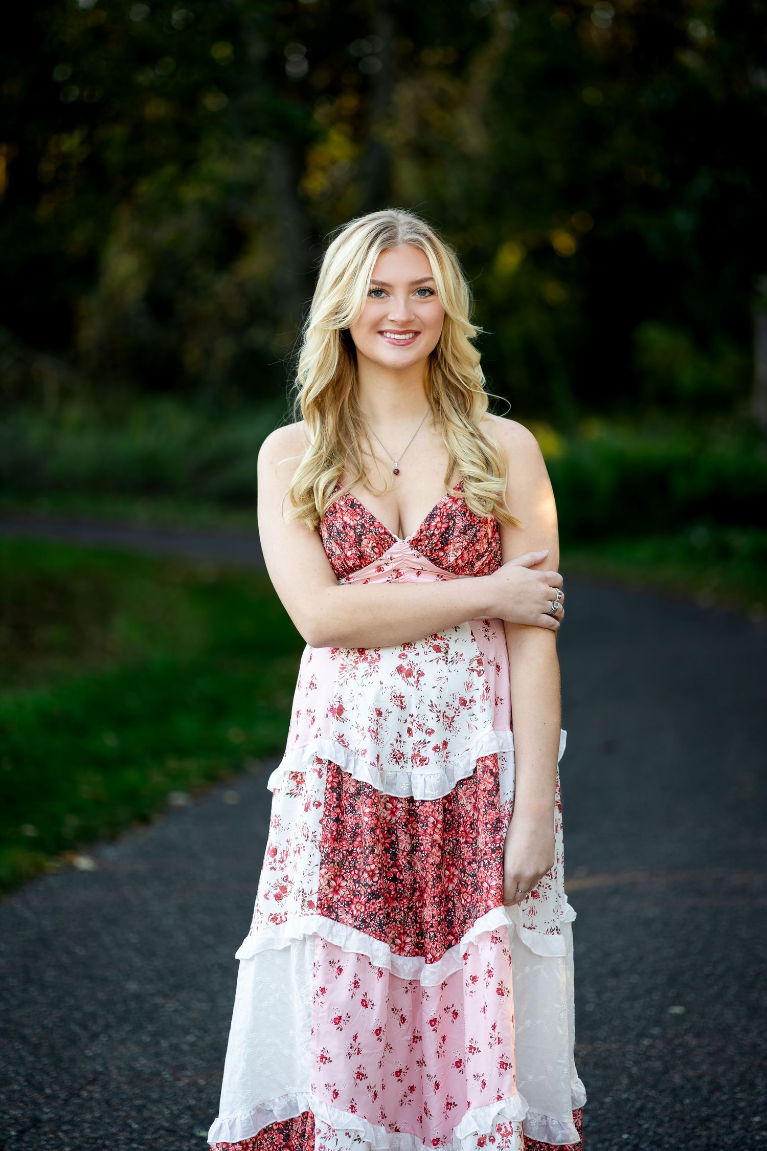 A series of outdoor portrait photos showing someone in a red and white floral dress against a natural background.
