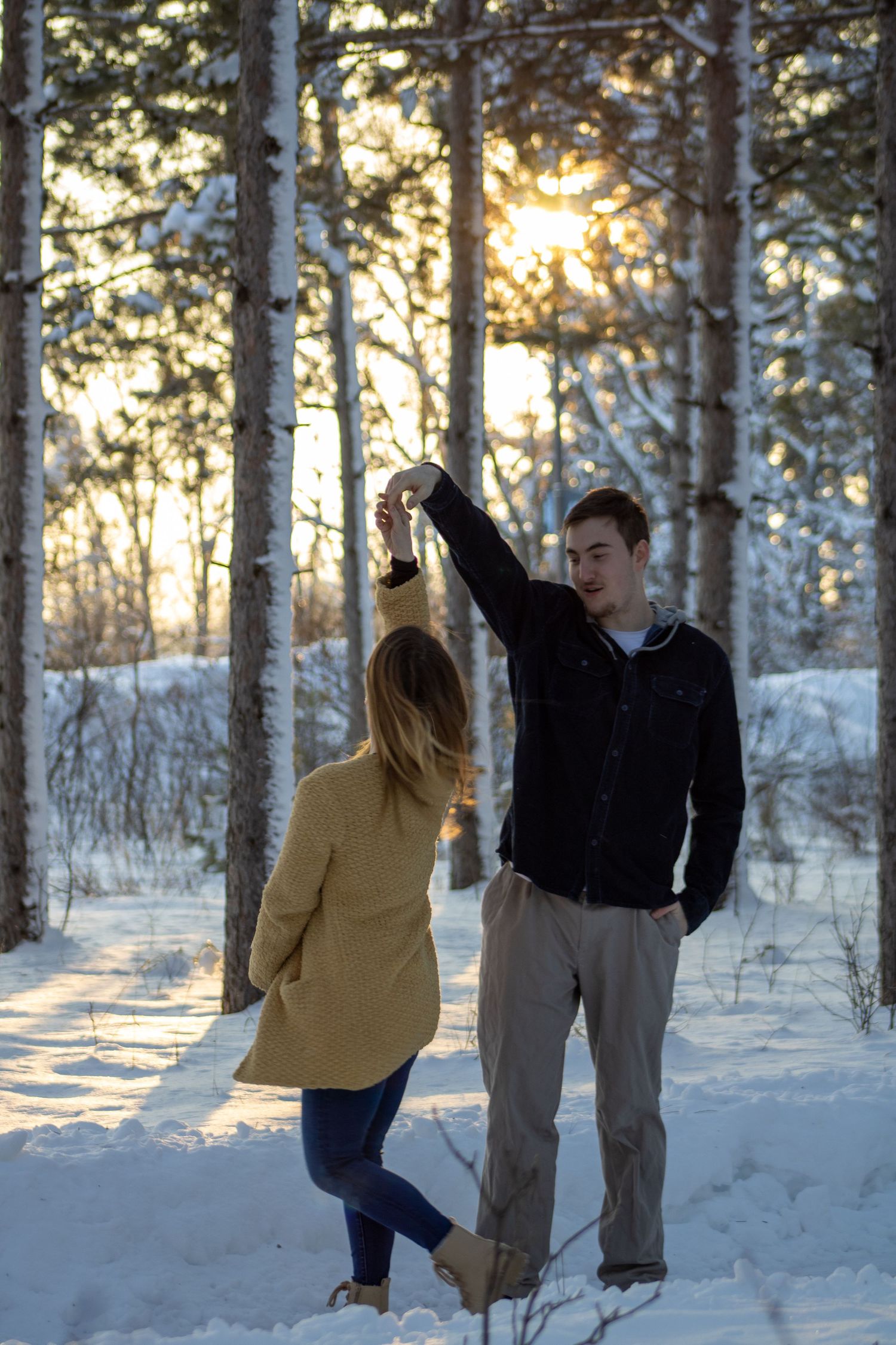 A series of joyful dance-like movements captured between two people in a snow-covered birch forest.