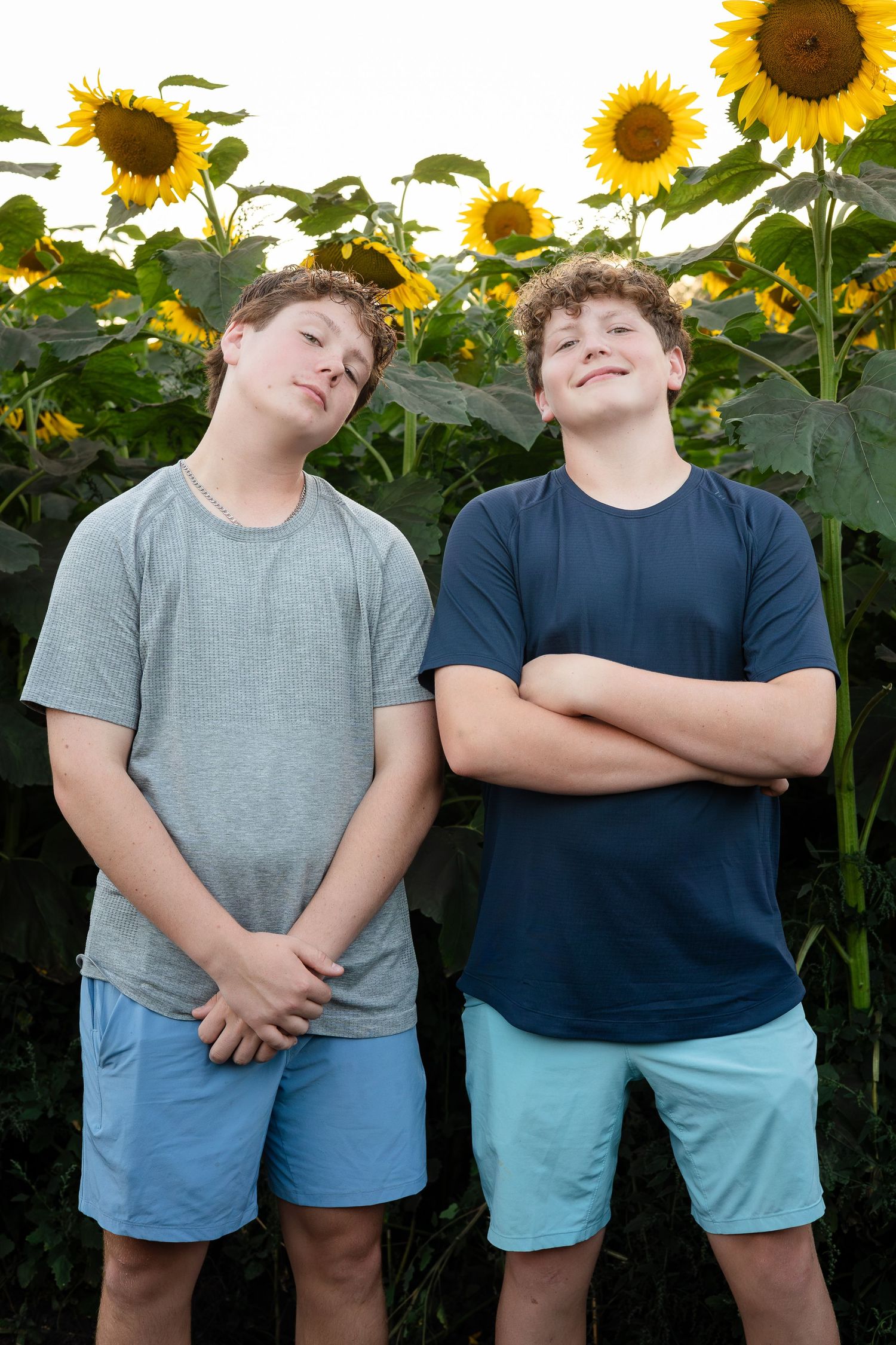 Children posing playfully against a backdrop of tall sunflowers.