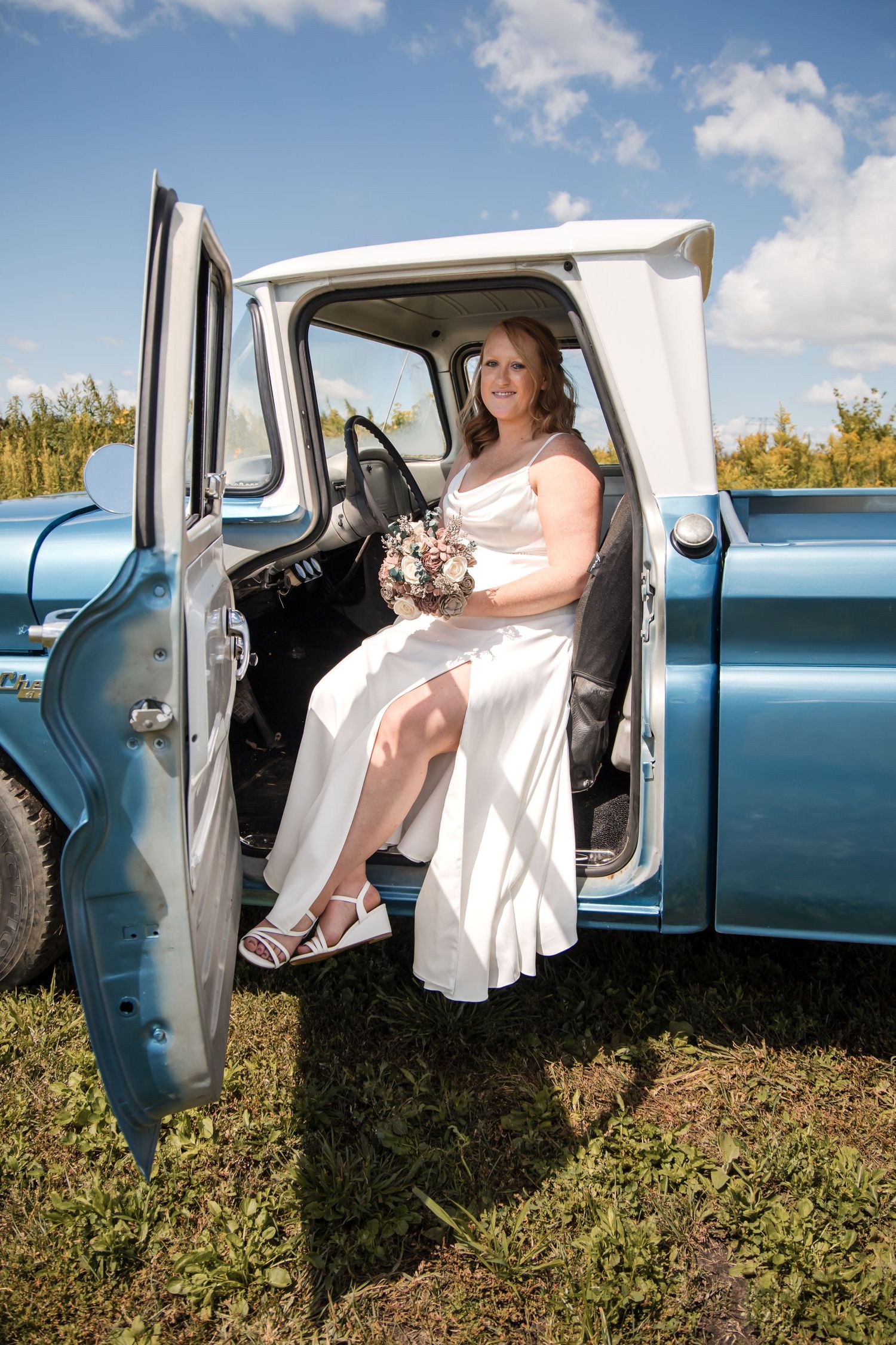 Sequence of a bride in white dress getting into a vintage blue pickup truck.