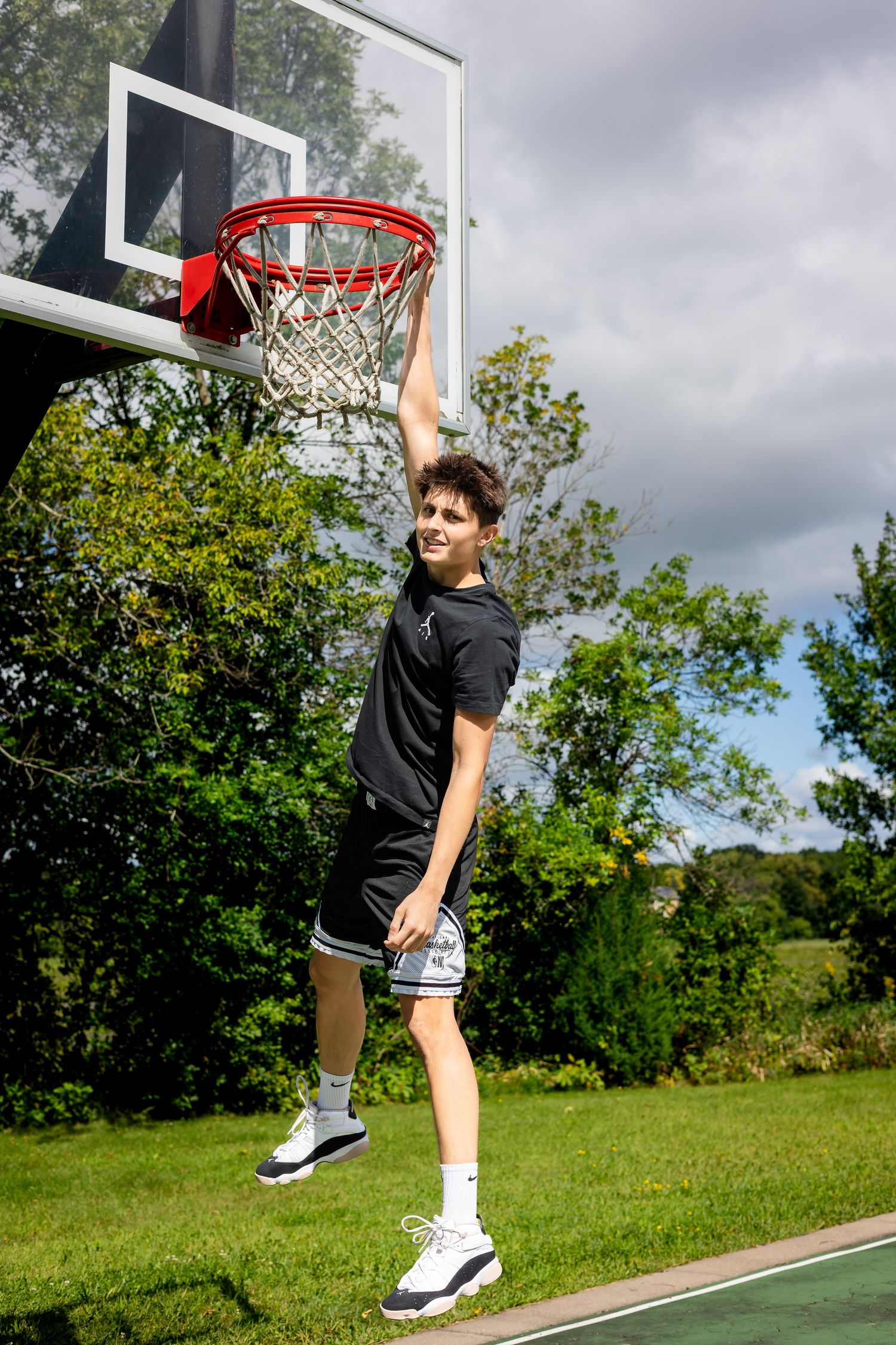 Basketball player jumping to make a shot on outdoor court.