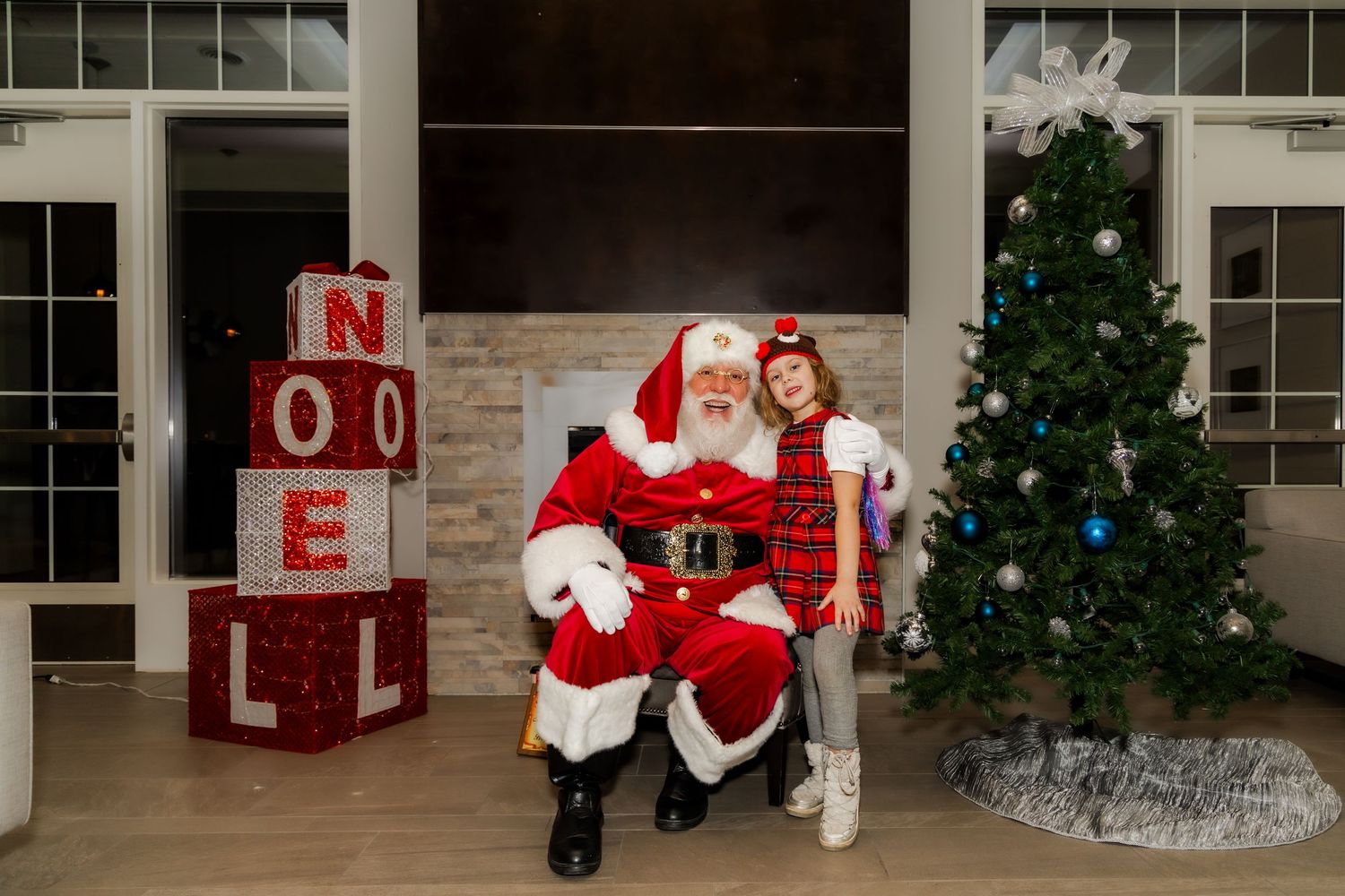 Holiday photo station featuring Christmas tree, NOEL signage, and seasonal decorations.