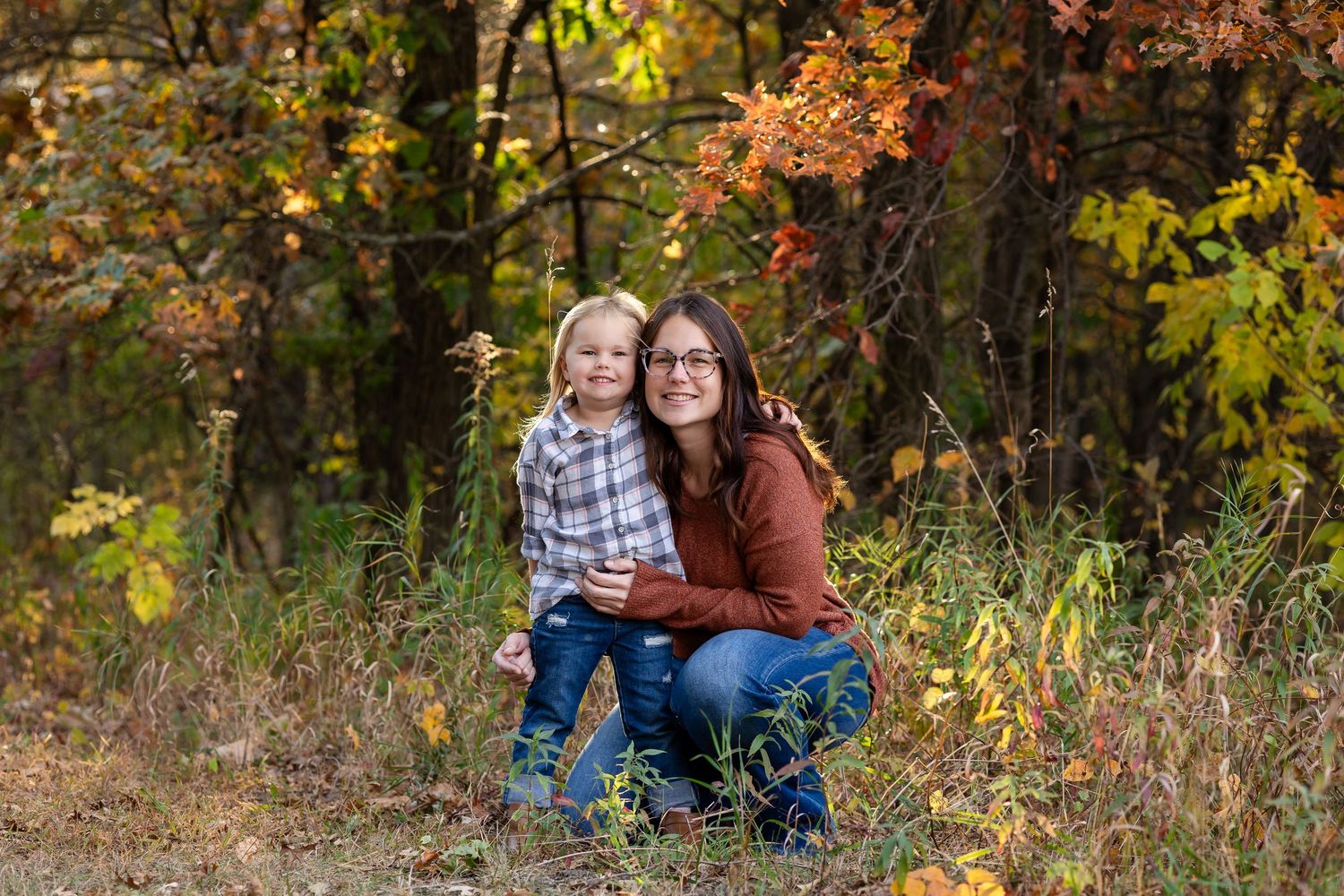 Family enjoying a casual autumn photoshoot in a field with golden light.