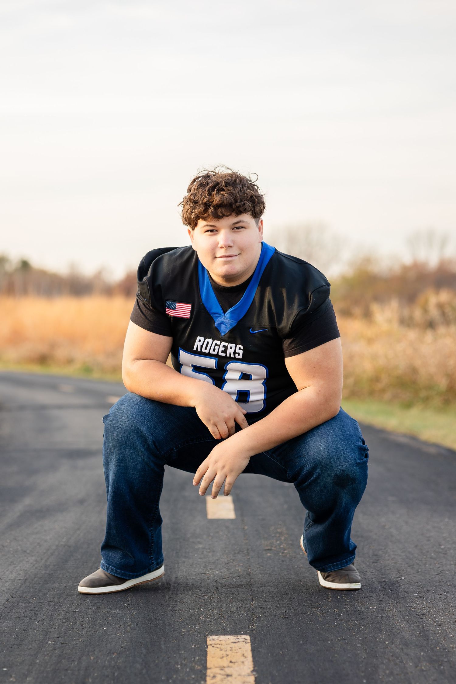 Athletic wear portrait with American flag patch on asphalt road.