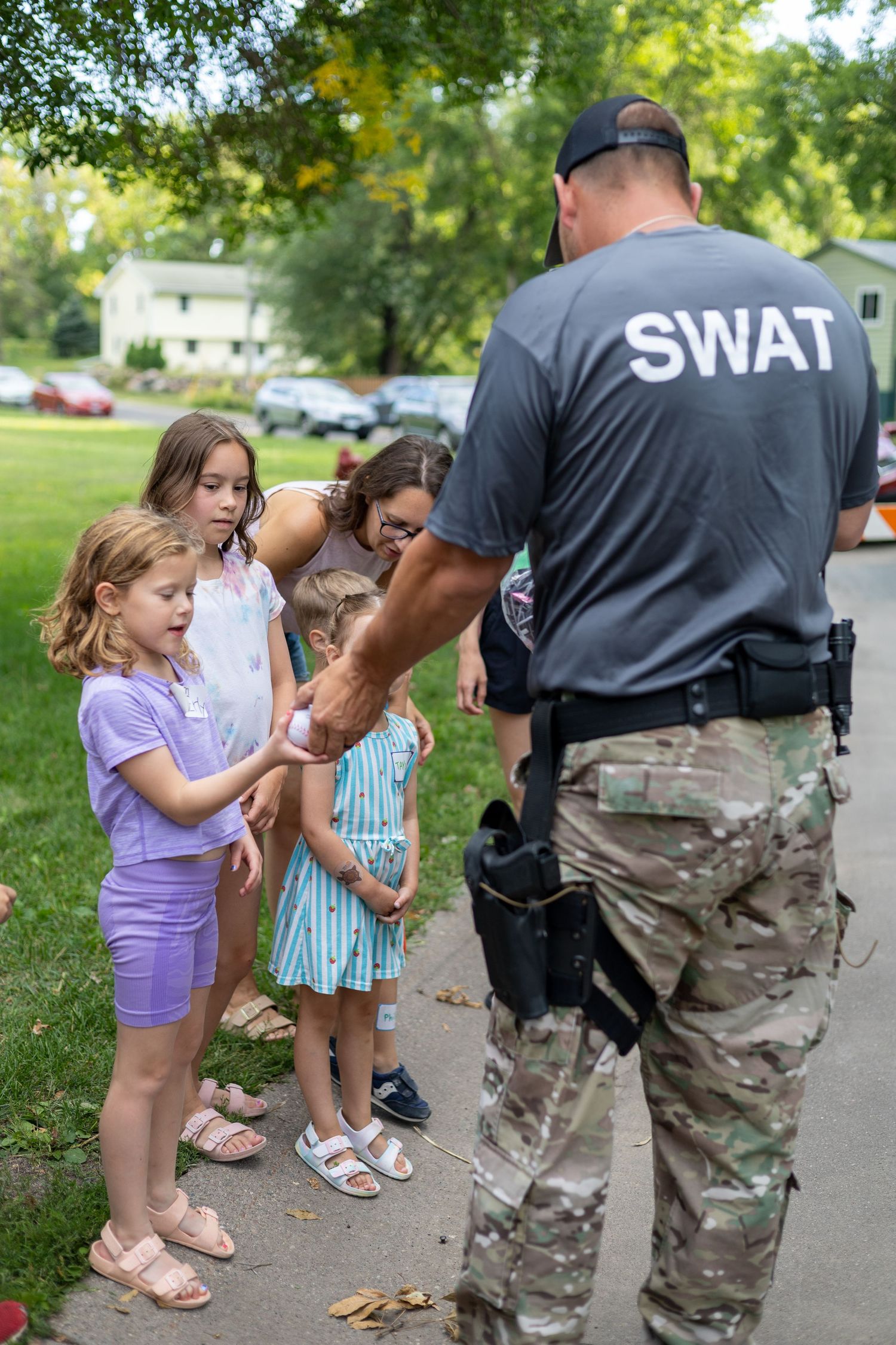 SWAT officers in tactical gear meeting with children on a community outreach event.