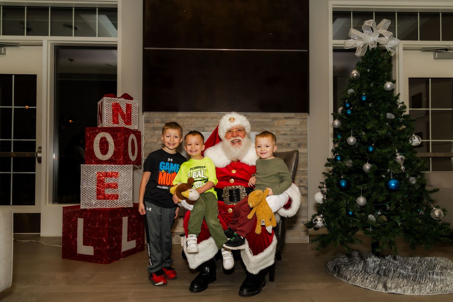 Festive Christmas photo setup with decorated tree and NOEL letters in bright display.