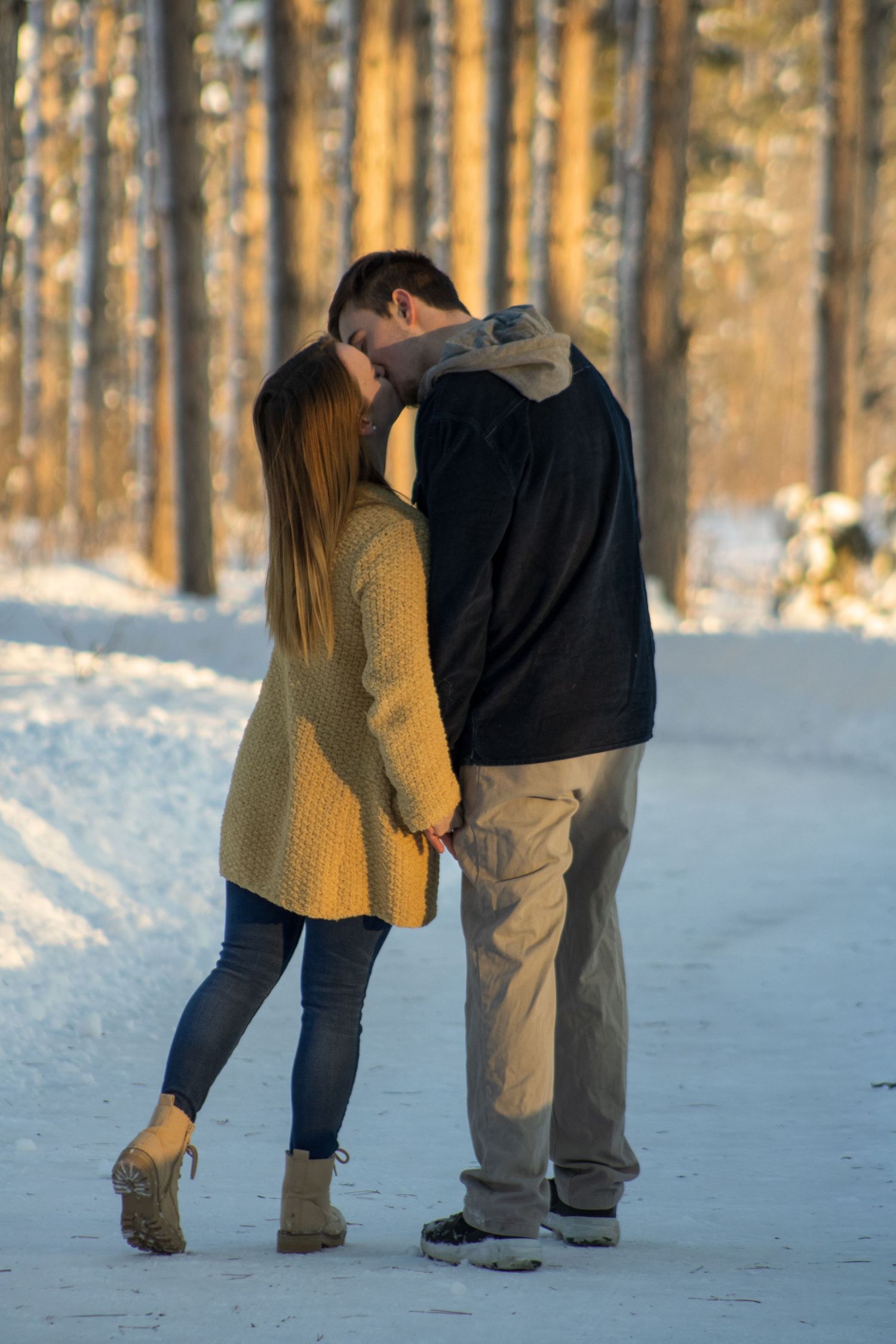 A series of candid moments between two people playing in the snow among birch trees.