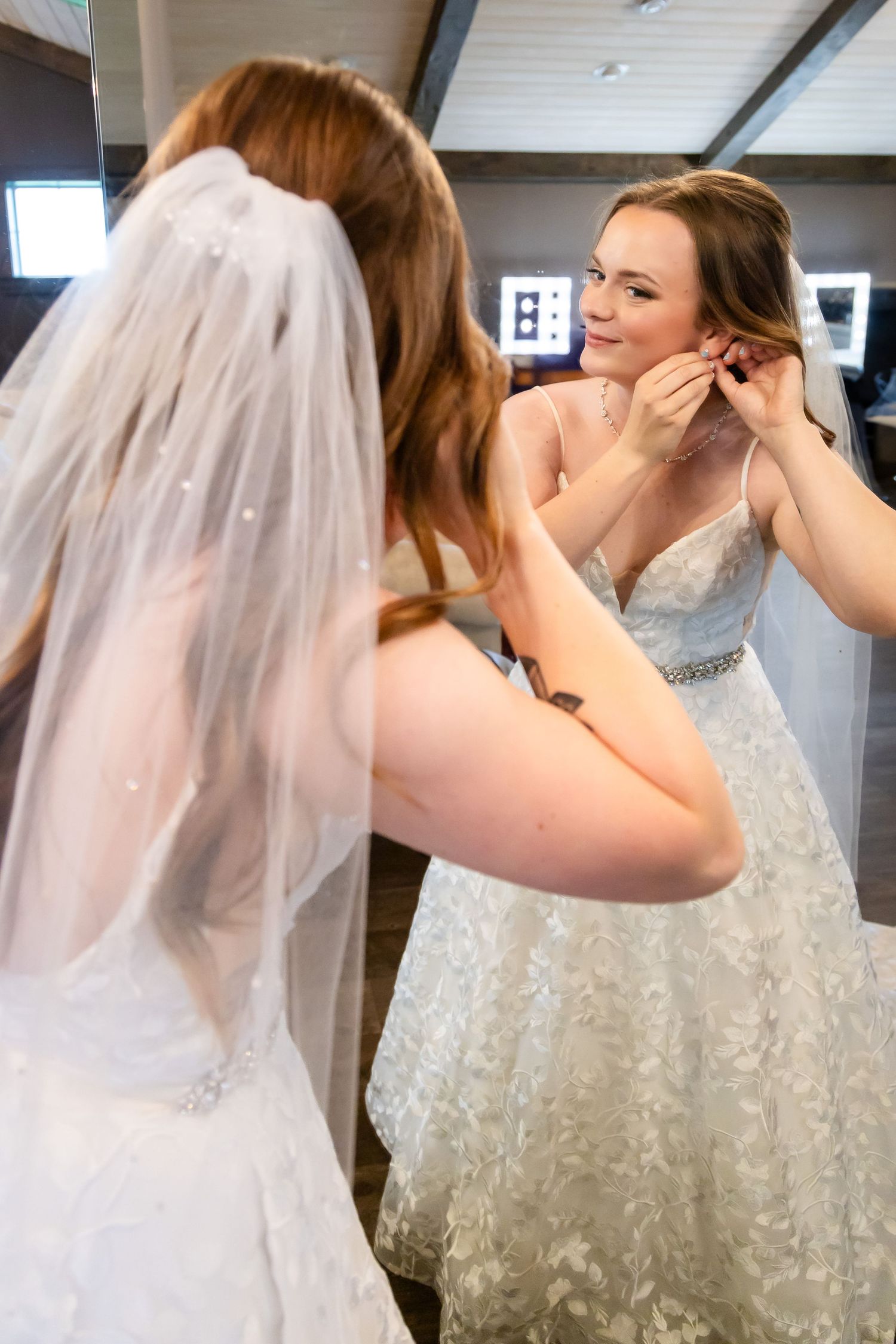 Getting ready sequence showing final wedding dress and veil adjustments.