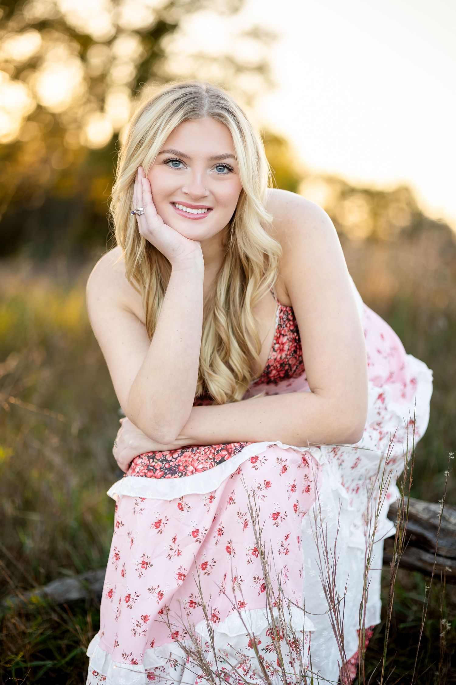 Outdoor portrait series at golden hour featuring someone in a red and white floral dress resting on their arms.