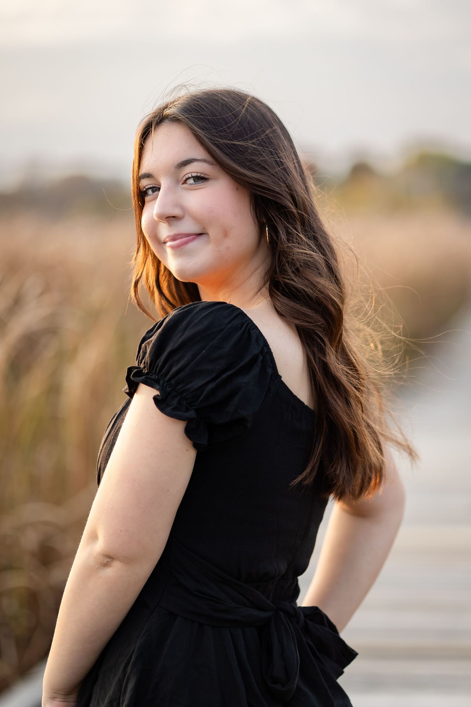 Natural light portrait series in black dress with wind-swept hair.