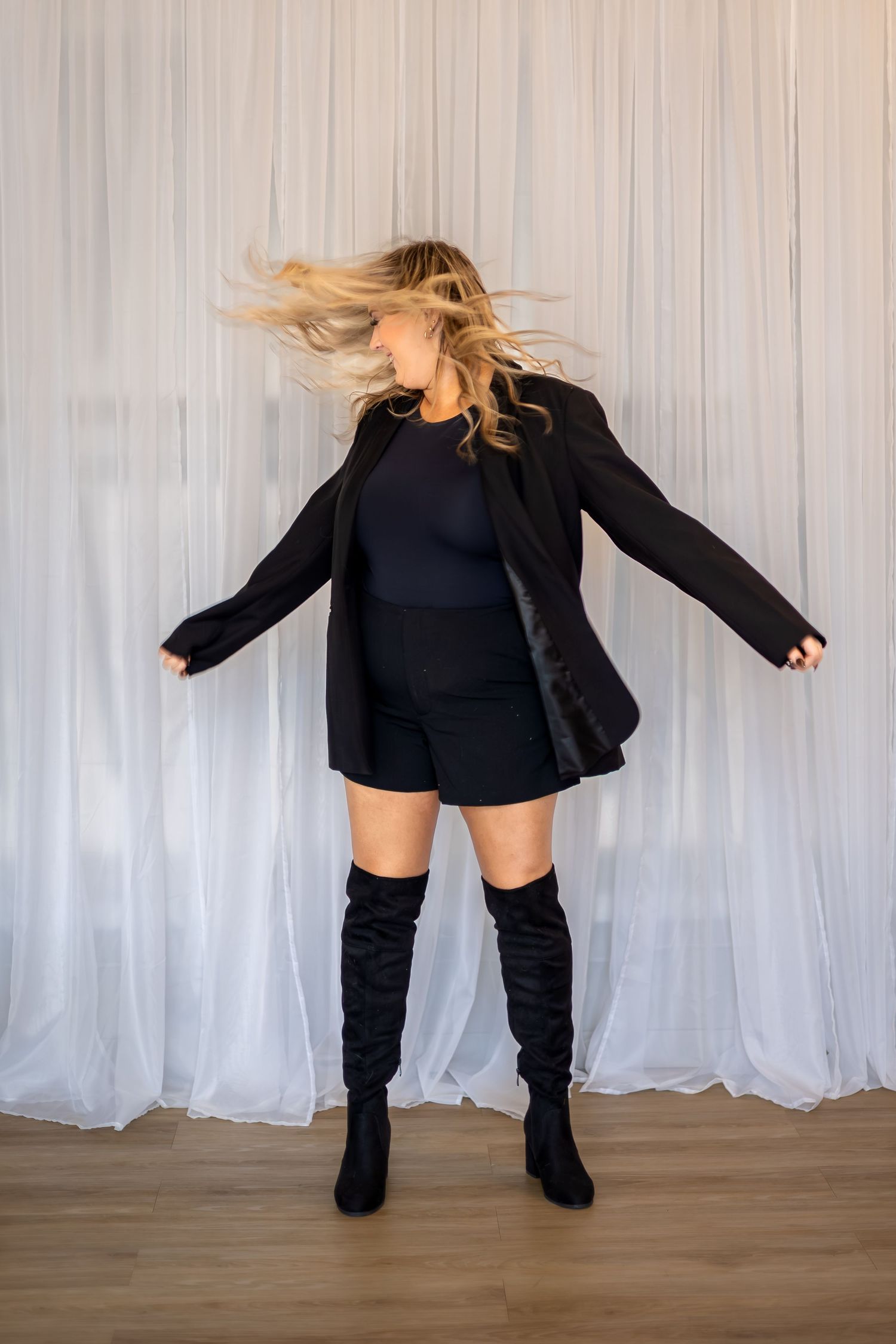 A sequence of five dance poses showing someone in black boots and outfit against a white curtain background.