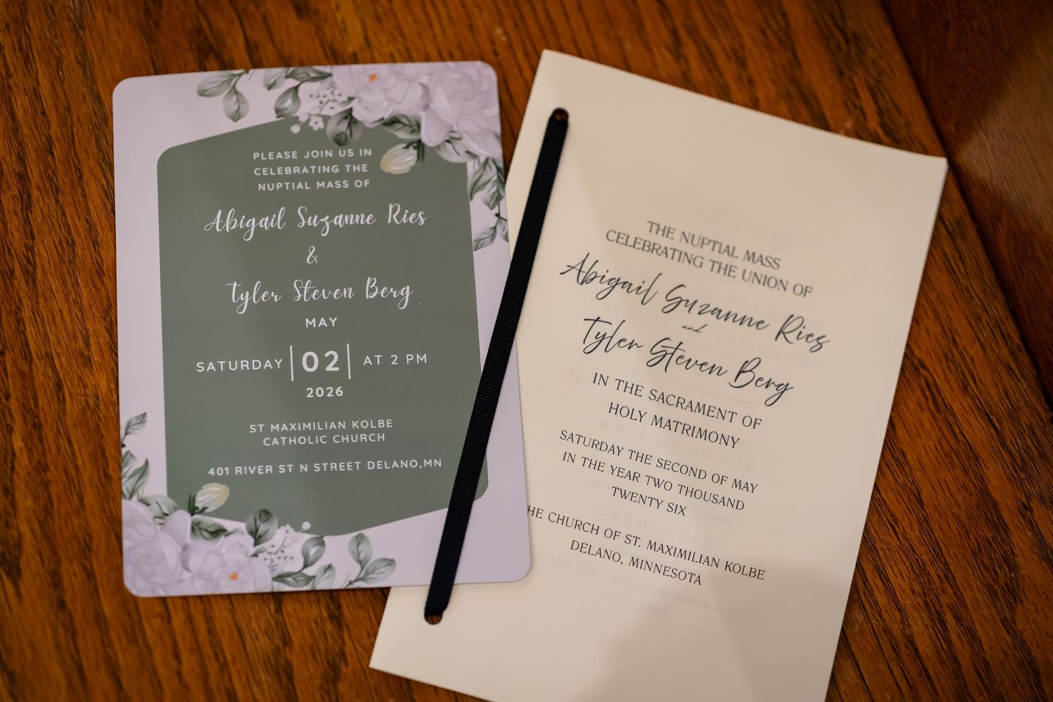 Wedding invitation and program for Abigail Suzanne Rios and Tyler Glenn Berg on a wooden table.