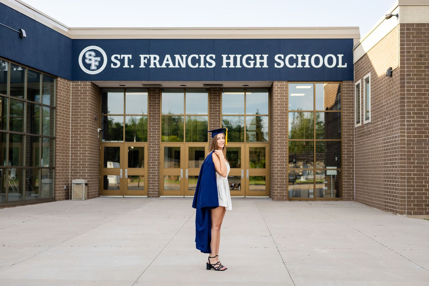 Wide angle view of St. Francis High School entrance with concrete plaza.
