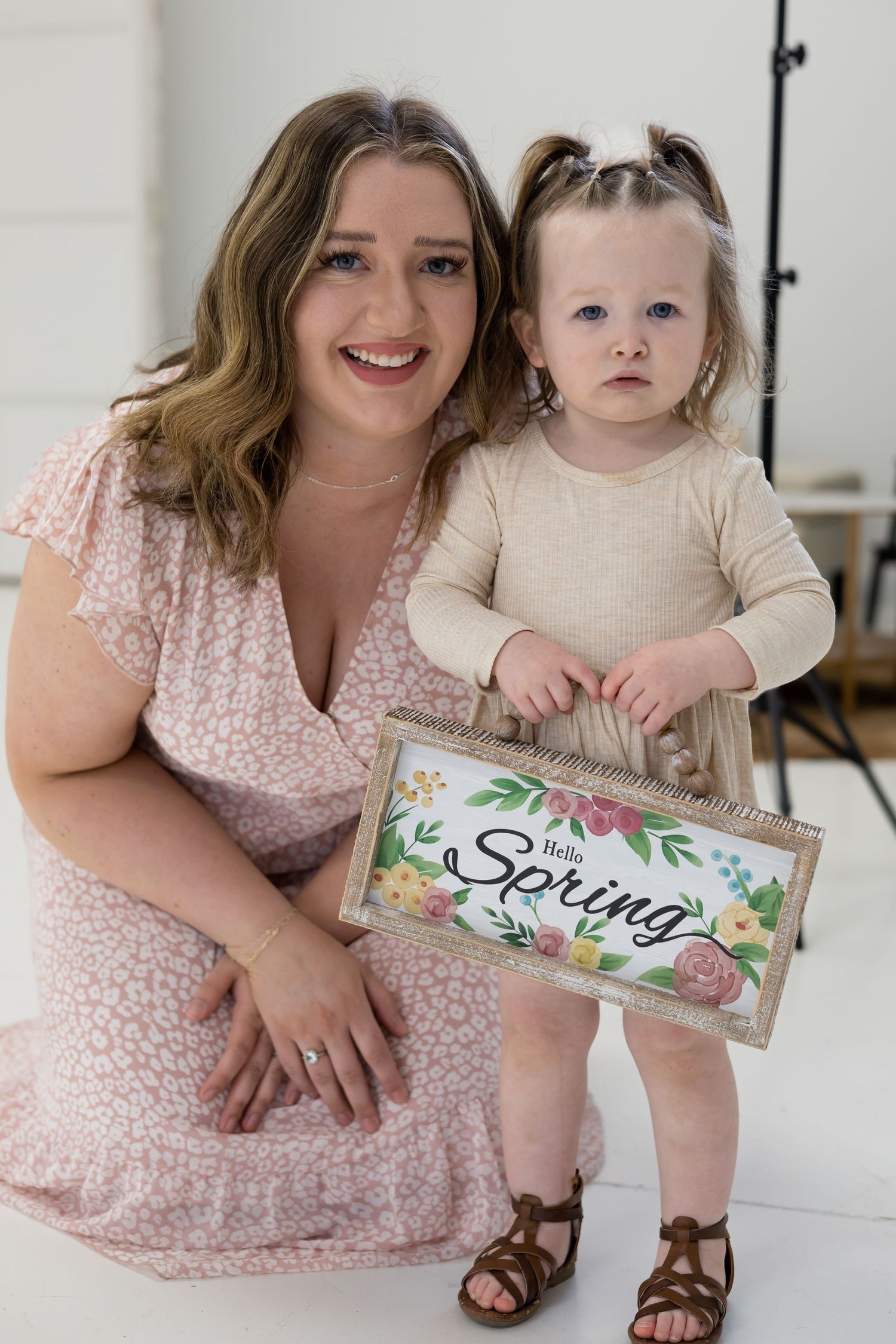 A spring-themed portrait session featuring a decorative sign and coordinated neutral outfits.