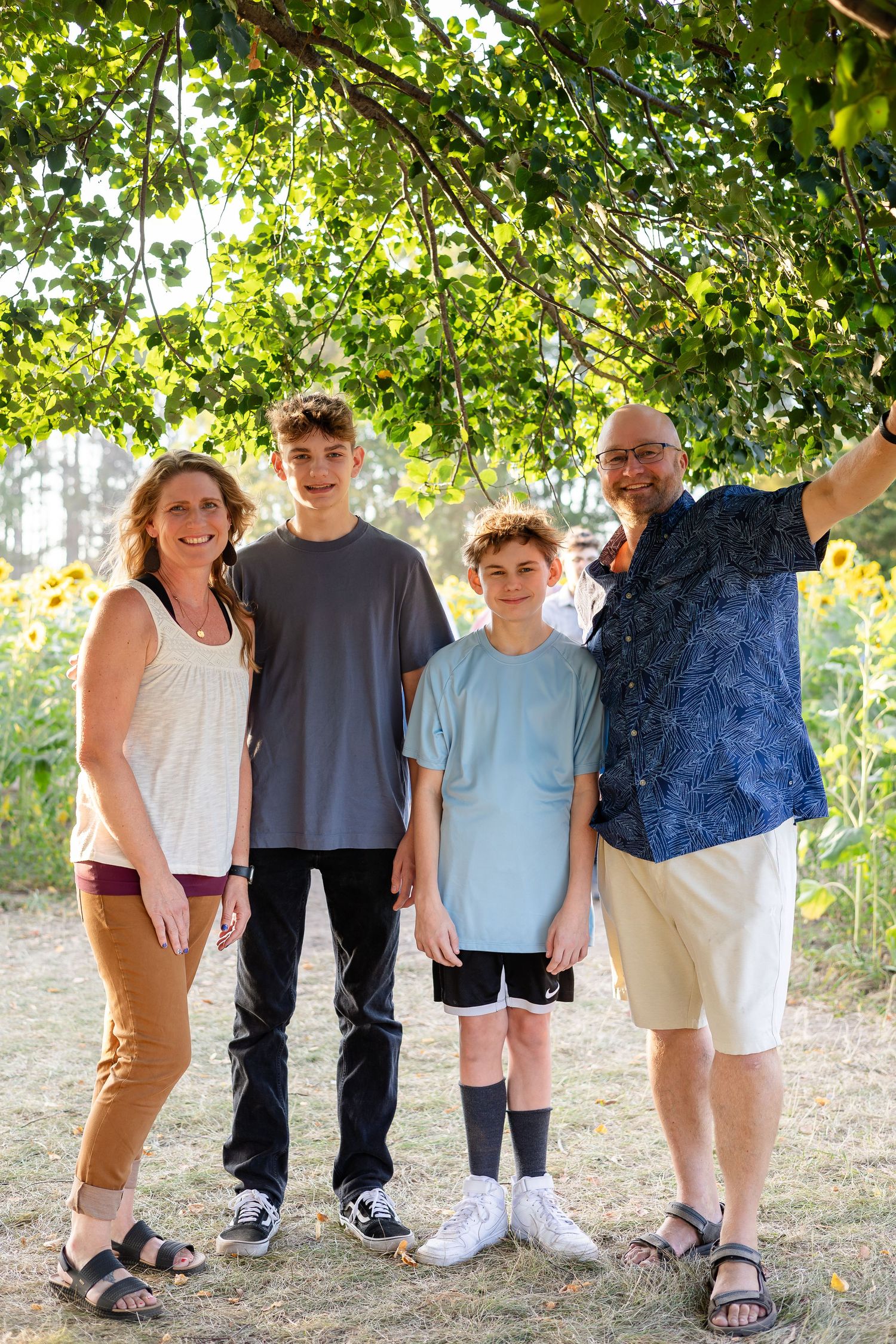 Group portrait in a natural outdoor setting with trees and greenery in the background.