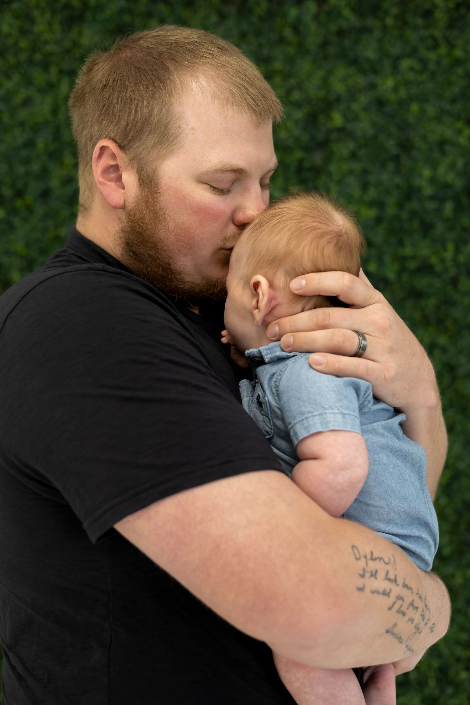An emotional moment captured against greenery as gentle embrace is shared.