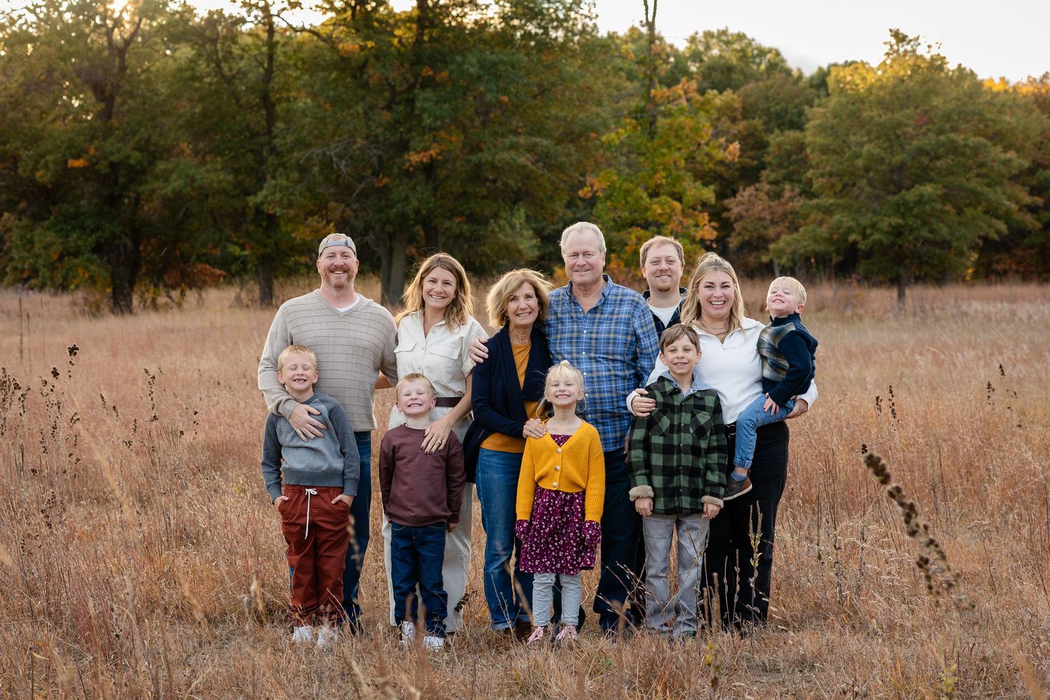 Group walking together through a golden autumn field at sunset.