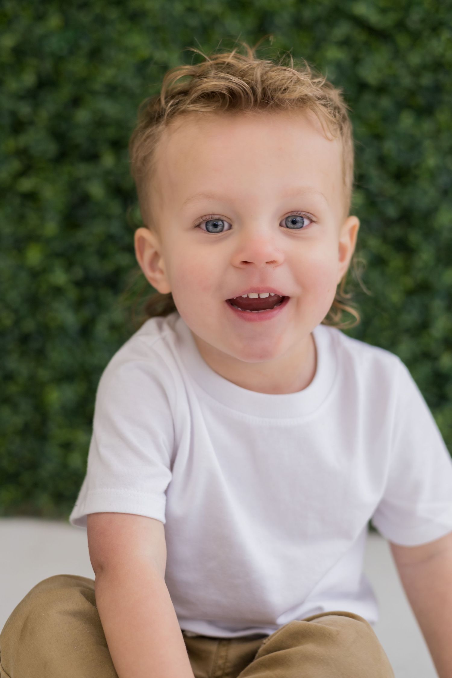 Close-up portraits of a toddler in white t-shirt showing joyful expressions.