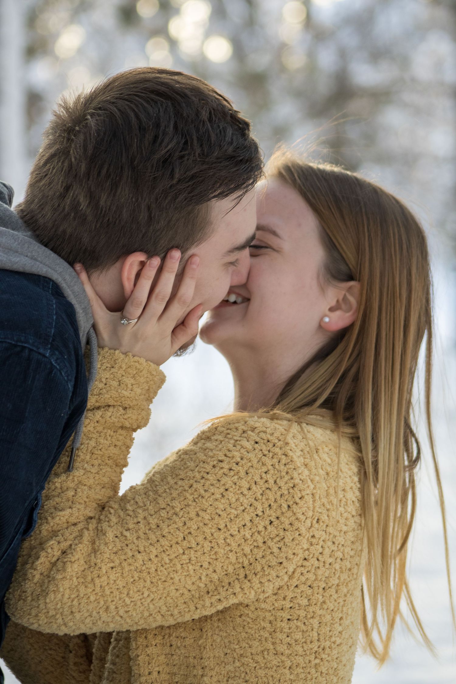 A romantic sequence showing an intimate moment between a couple in a snowy forest.